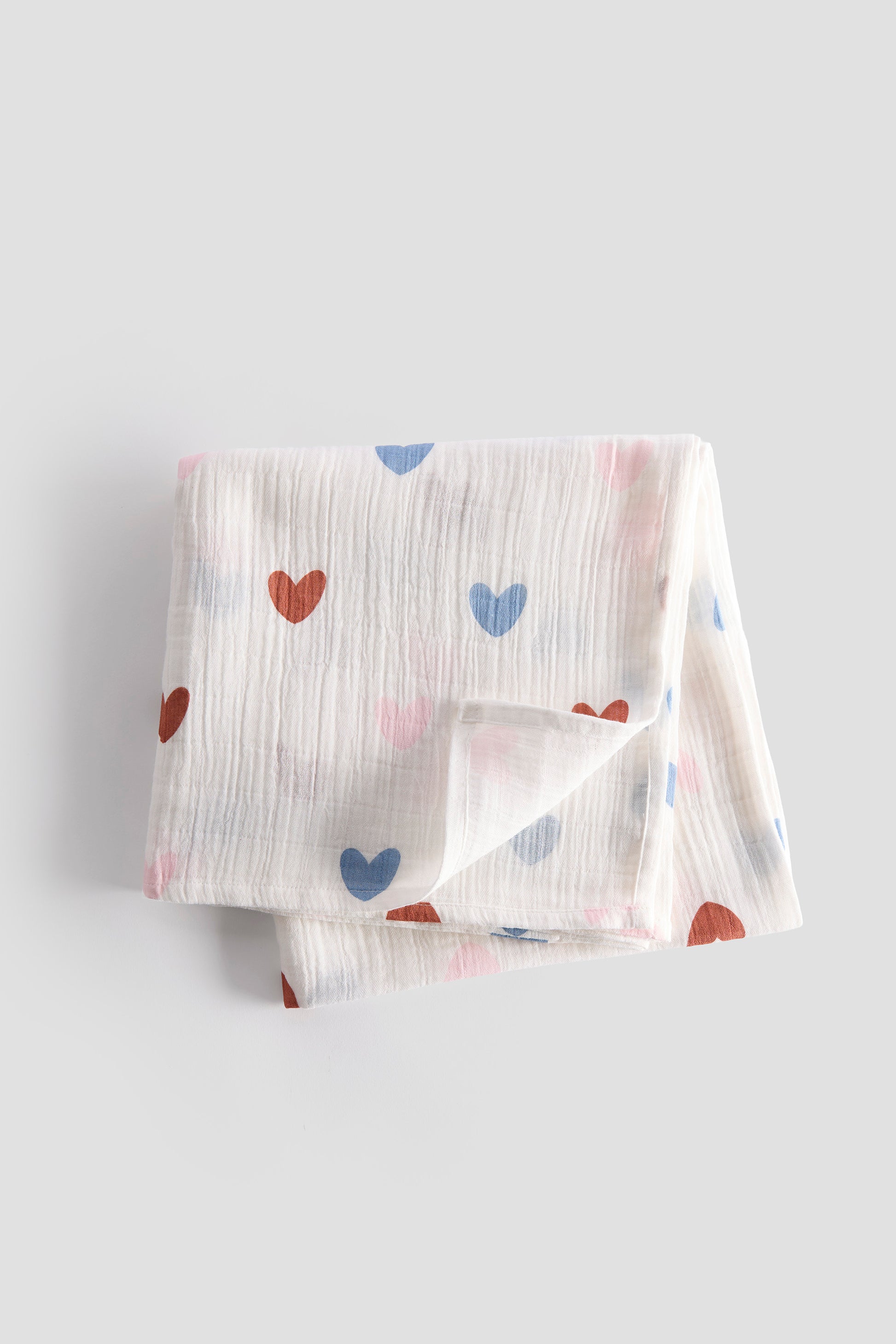 Baby blanket with heart patterns on a light gray background