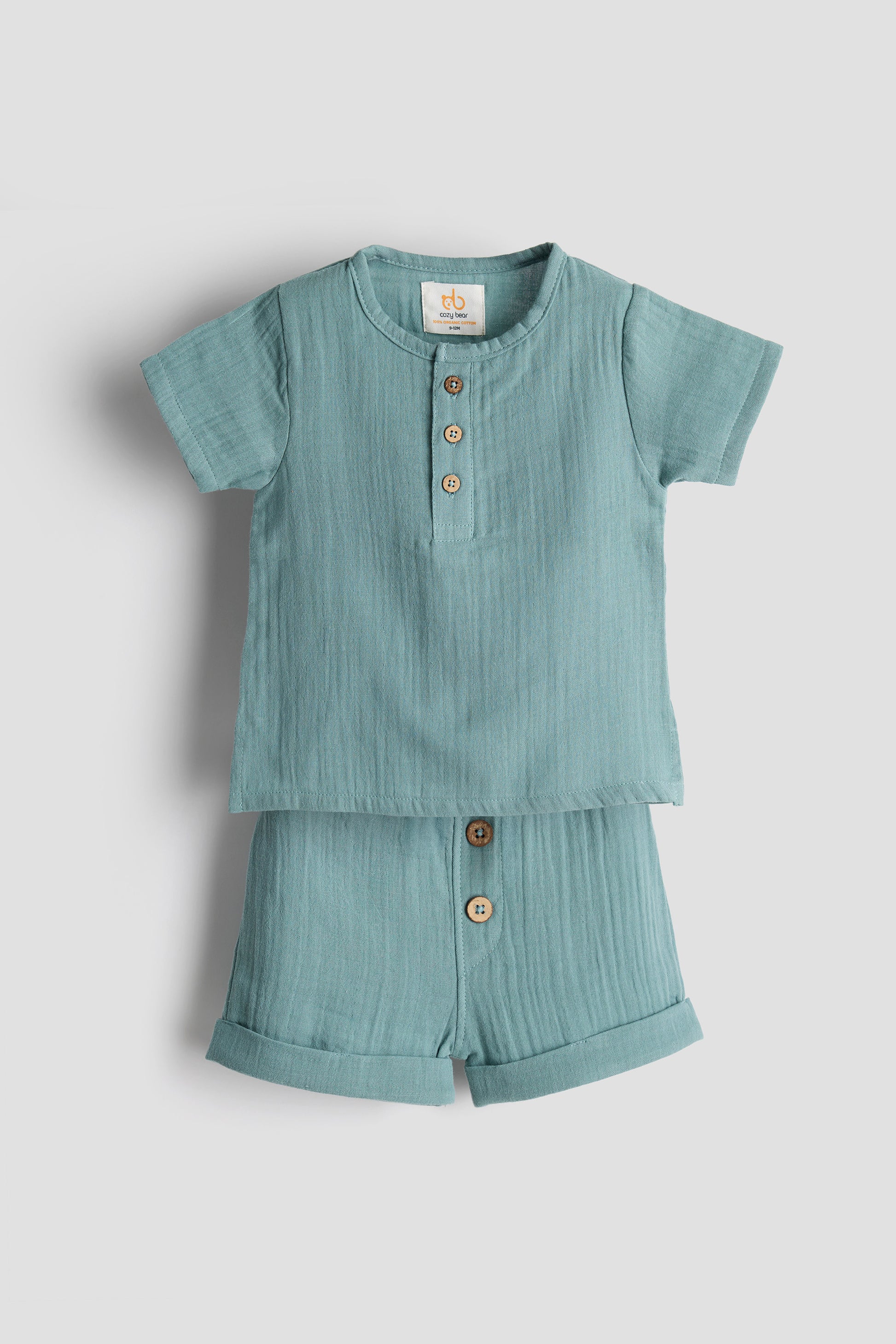 Light blue children's shirt and shorts set on a light gray background