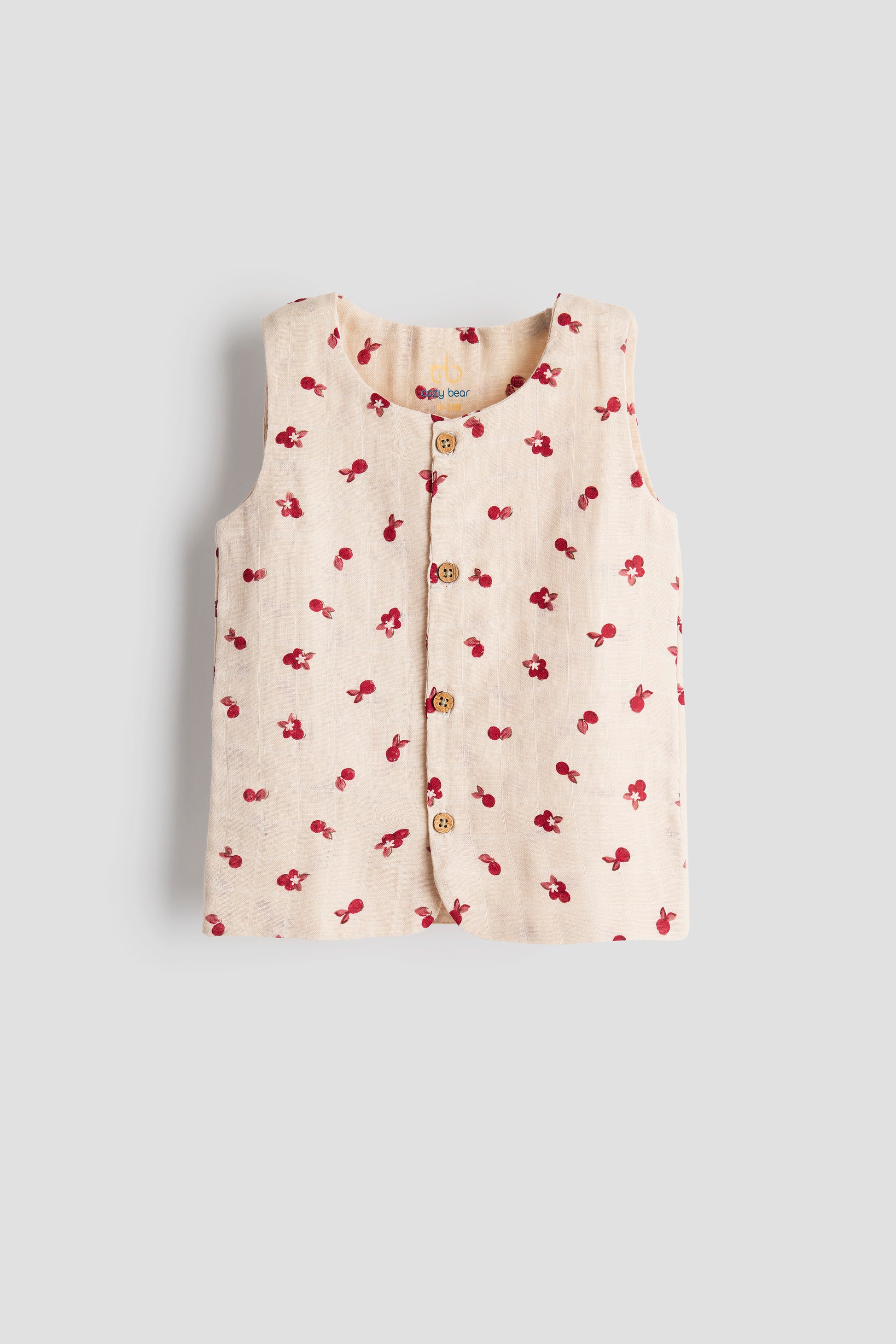 Baby vest with cherry pattern on a light gray background