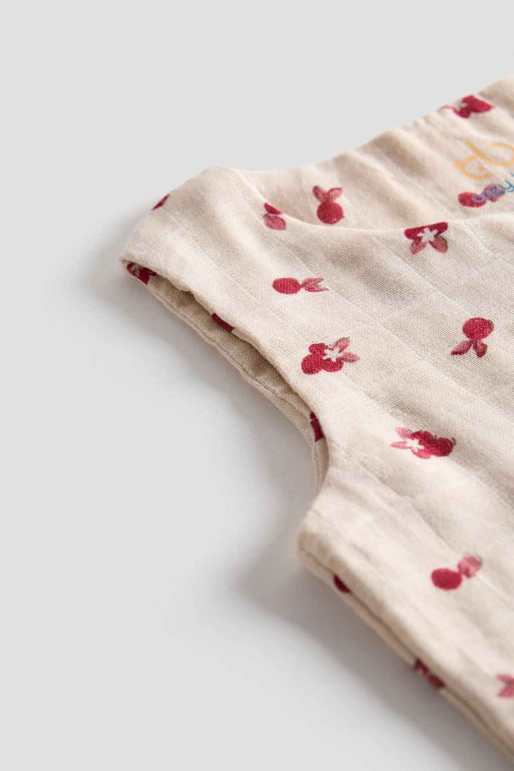 Beige fabric with red floral pattern on a light gray background