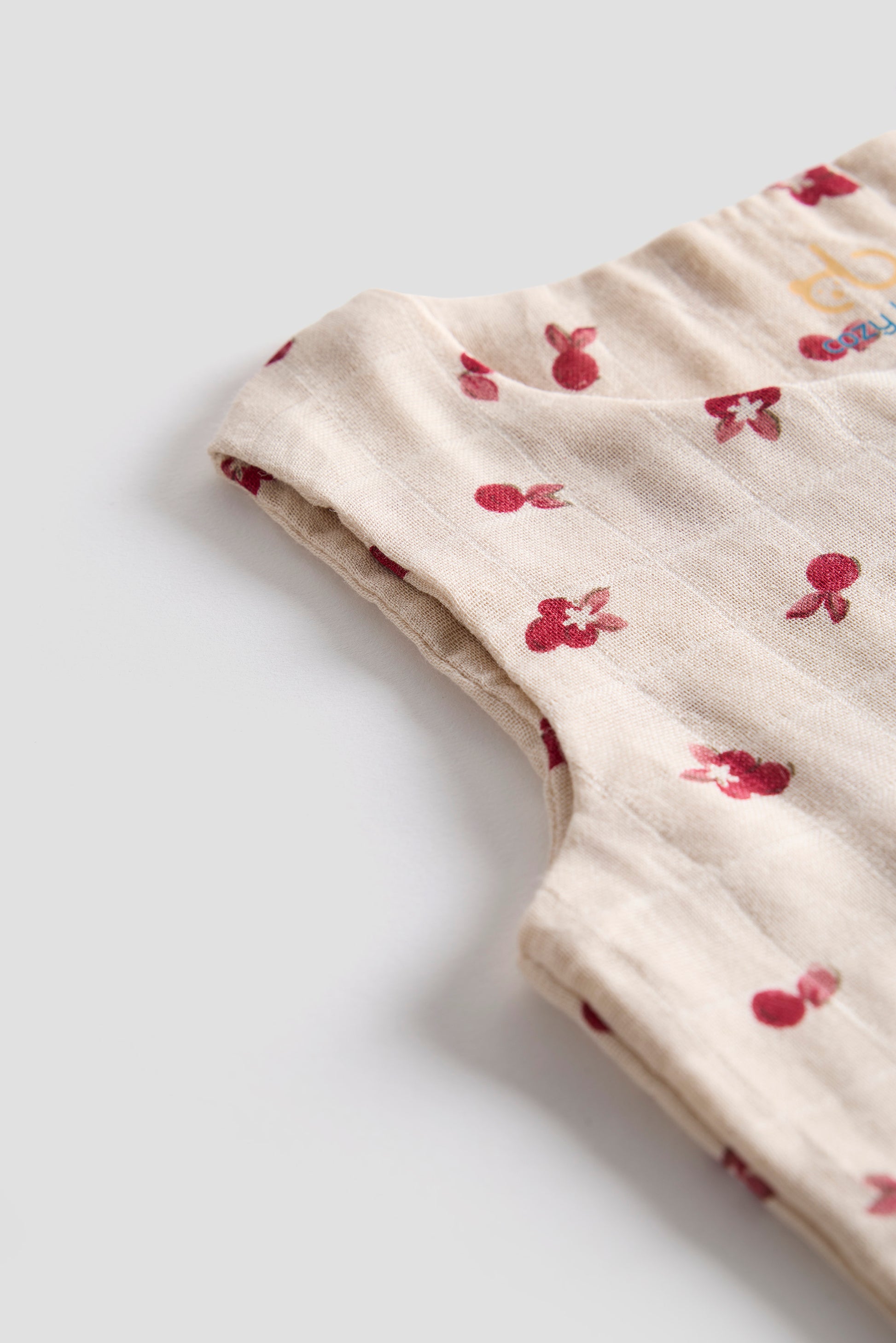 Beige fabric with red floral pattern on a light gray background