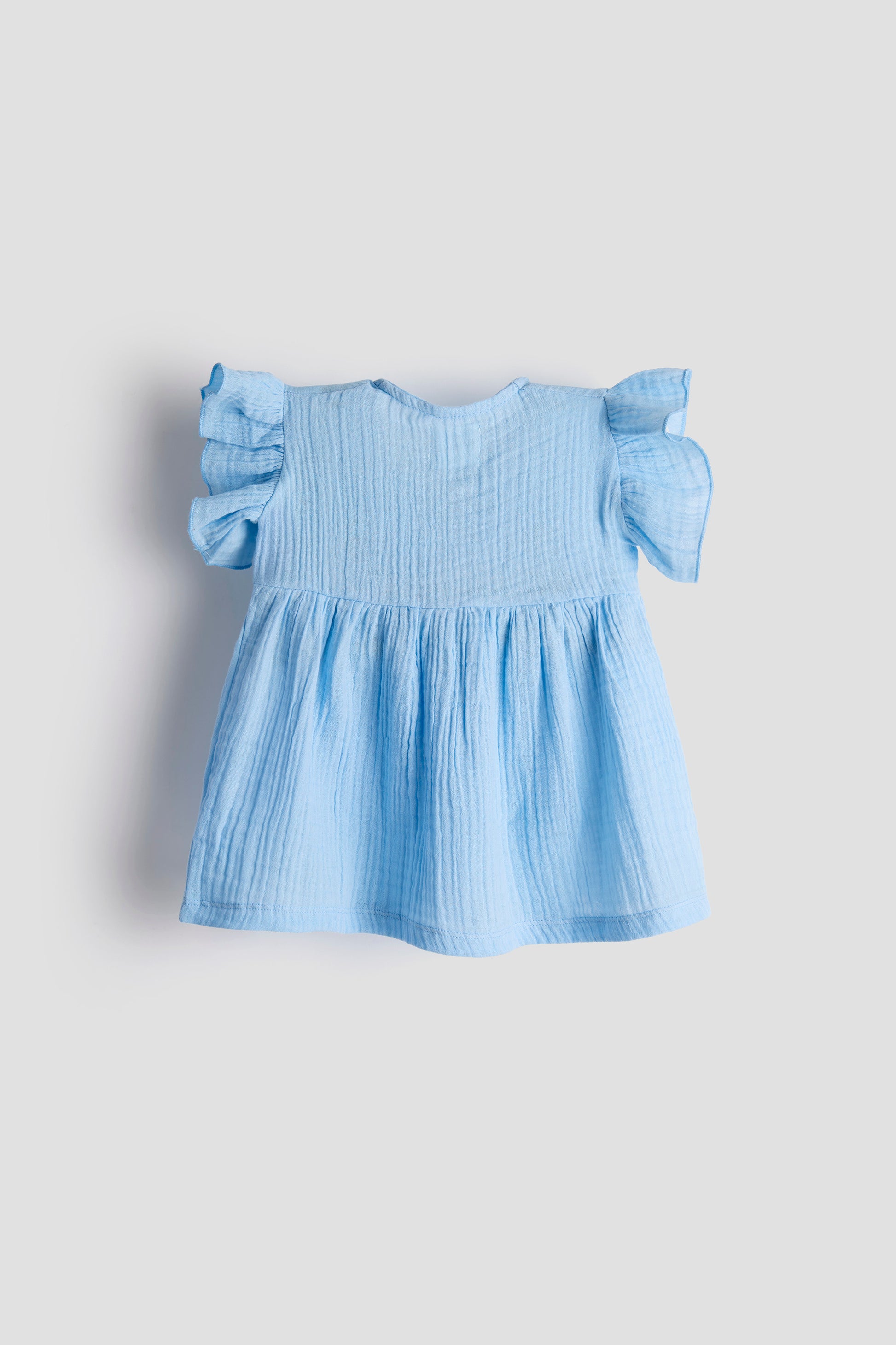 Light blue dress with ruffled sleeves on a light gray background