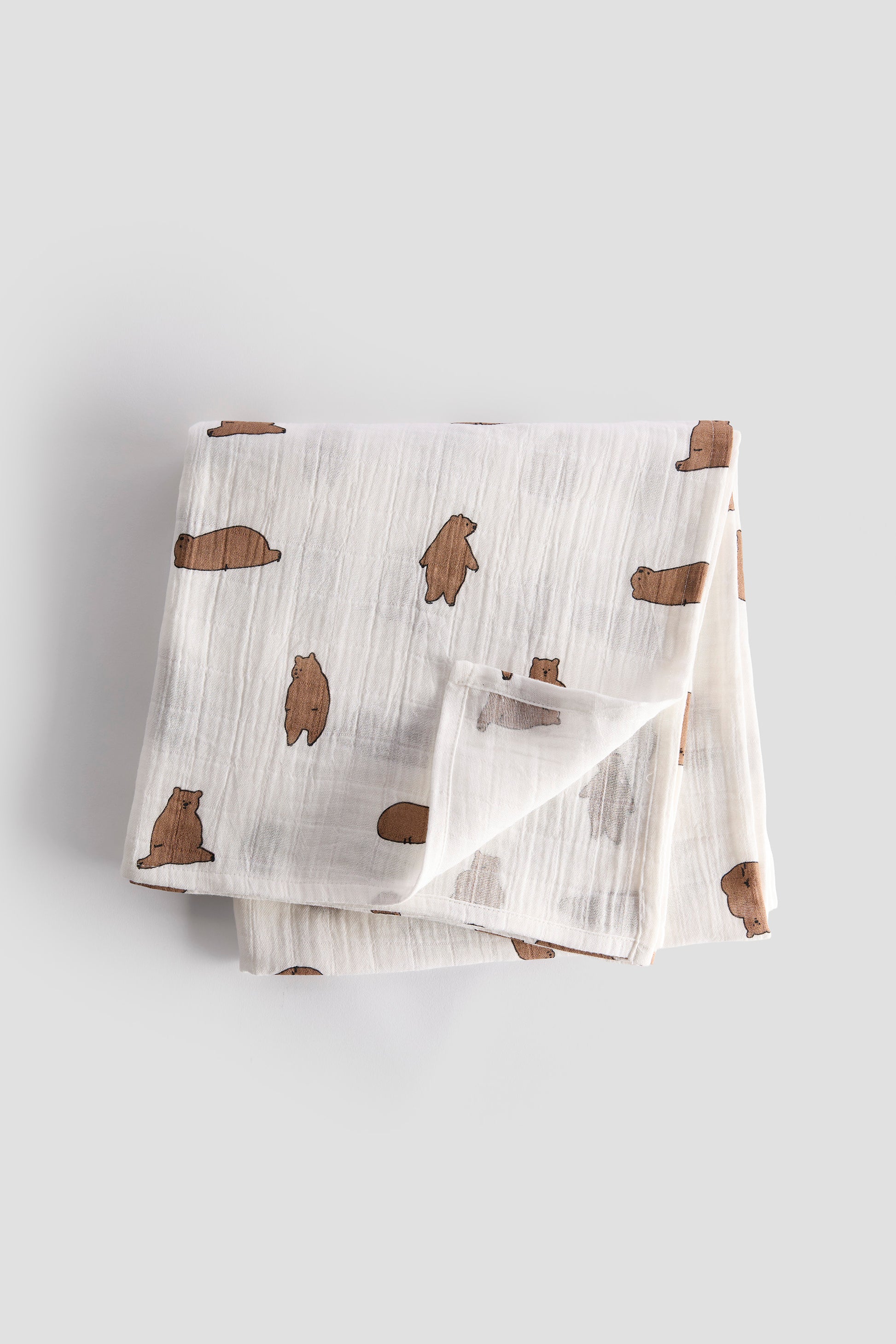Baby blanket with bear pattern on a light gray background