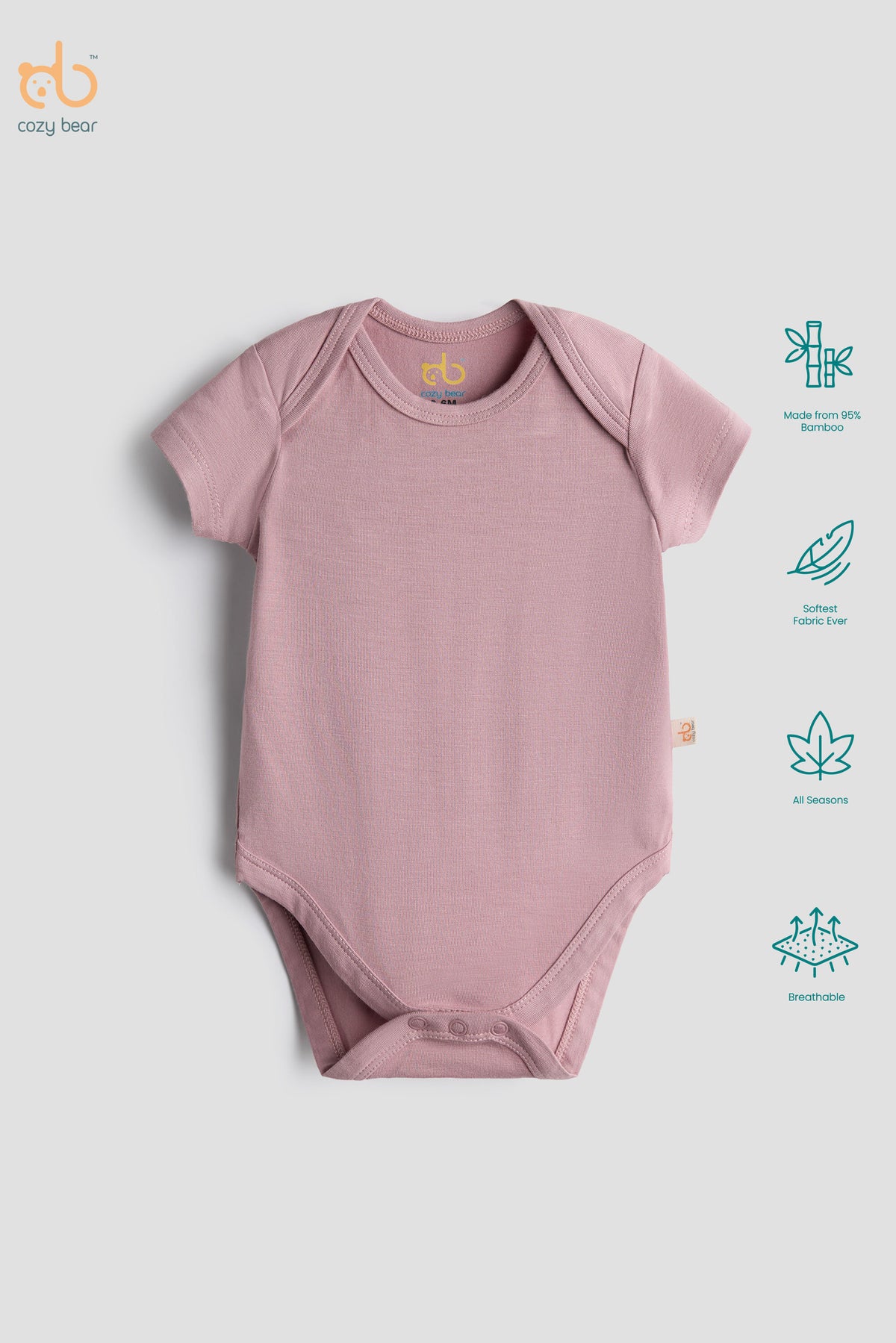 A dusty pink short-sleeve baby bodysuit laid flat on a light gray background, with the cozy bear logo in the top-left corner and feature icons along the right side.