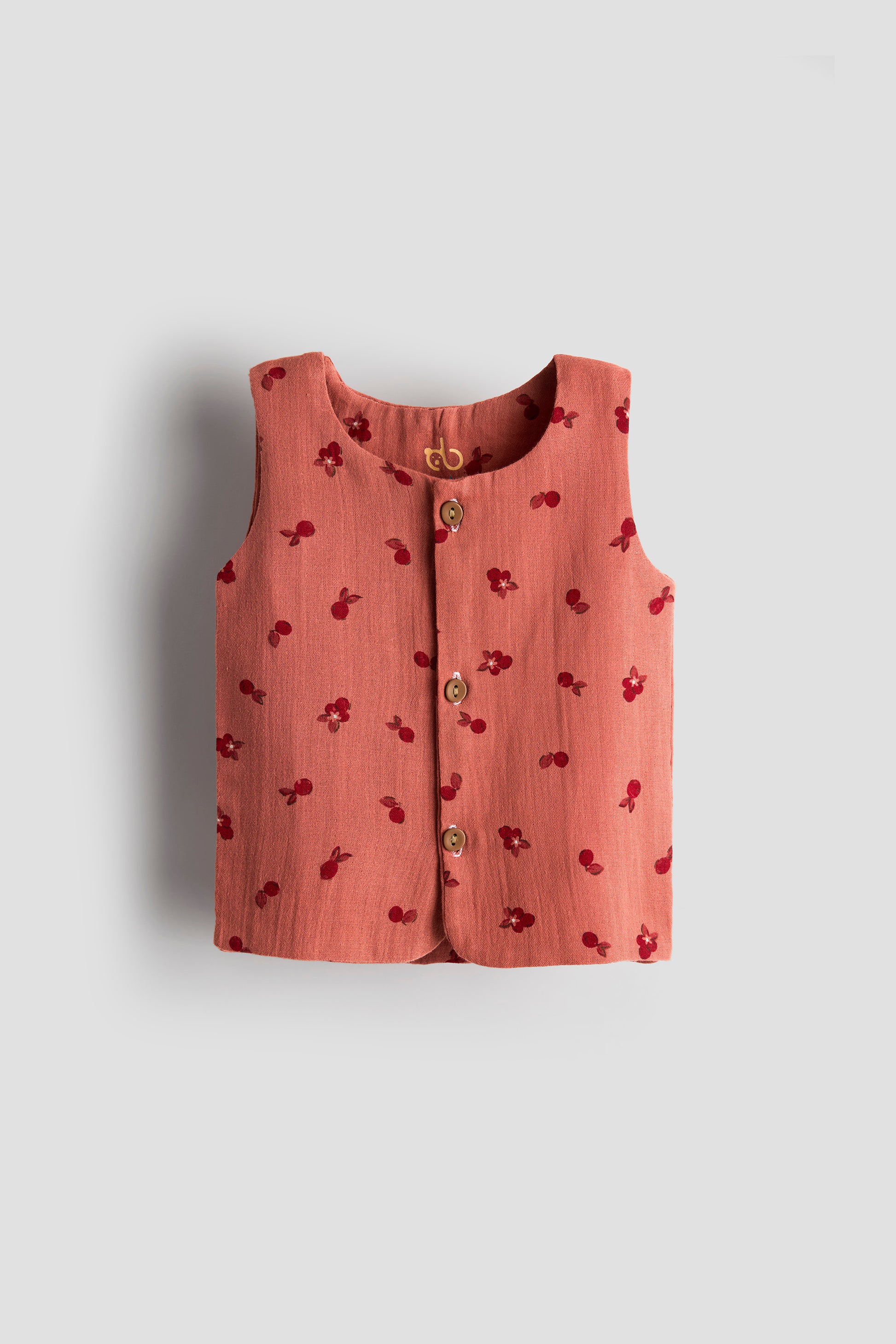 Pink sleeveless top with cherry pattern on a light gray background