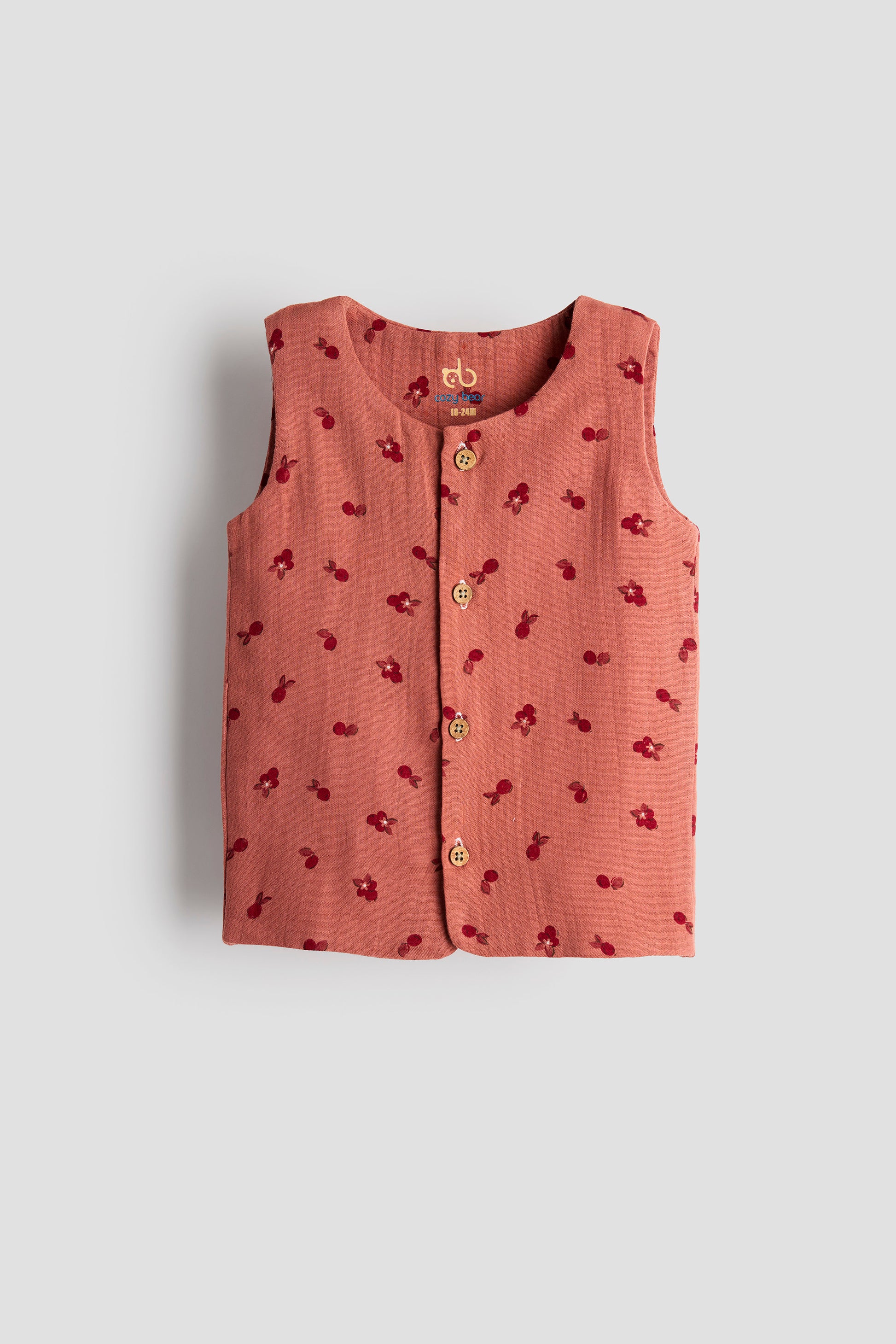 Pink sleeveless top with floral pattern on a light gray background