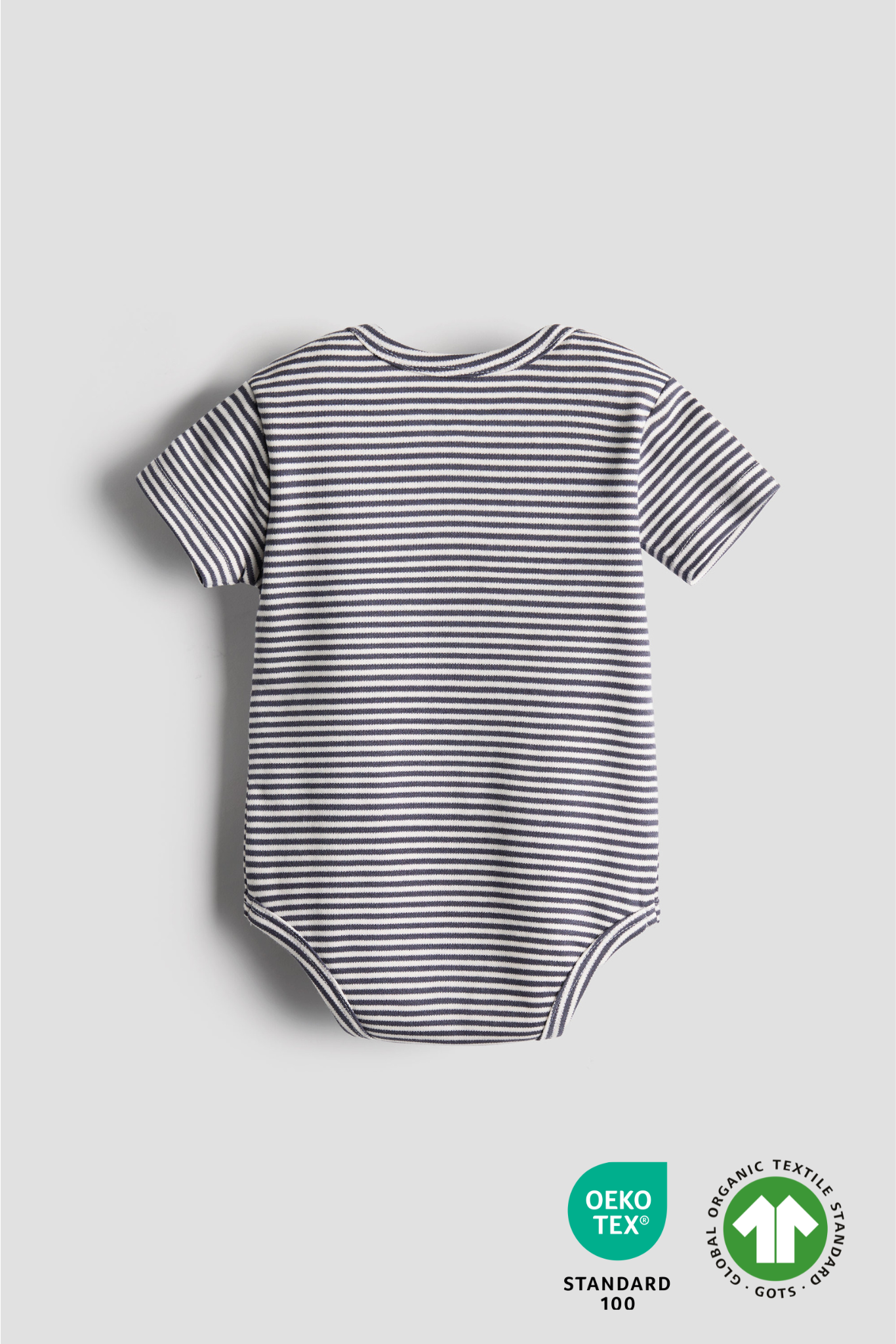 Striped baby bodysuit on a light gray background with OEKO-TEX certification logos.