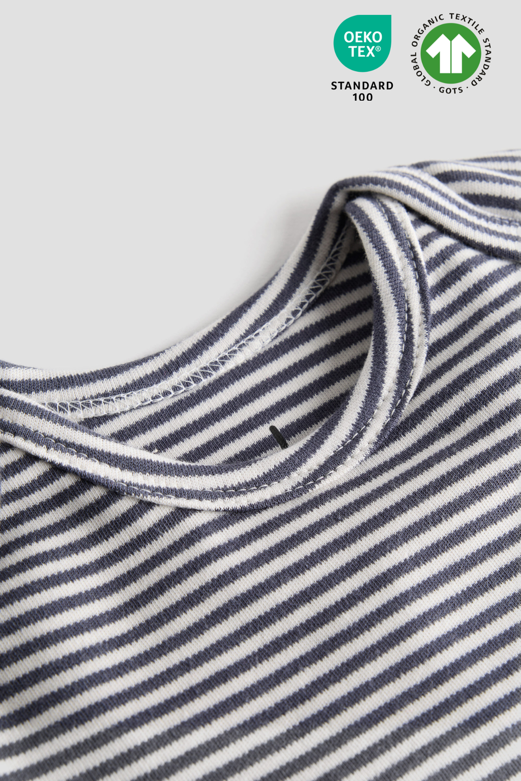 Close-up of a striped fabric with DEKOTEX Standard 100 logo on a white background