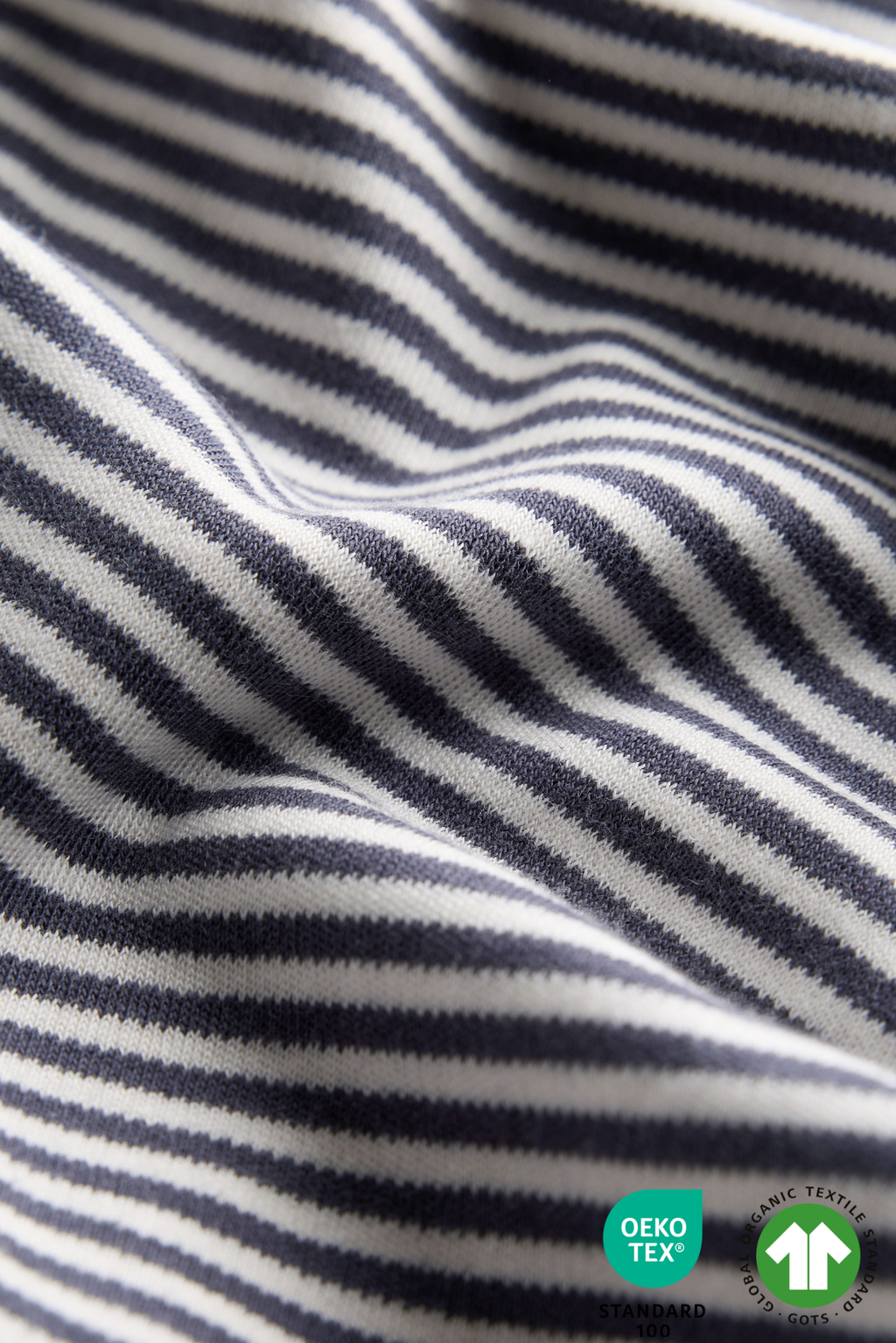 Close-up of striped fabric with Oeko-Tex and OEKO-TEX Standard 100 labels.