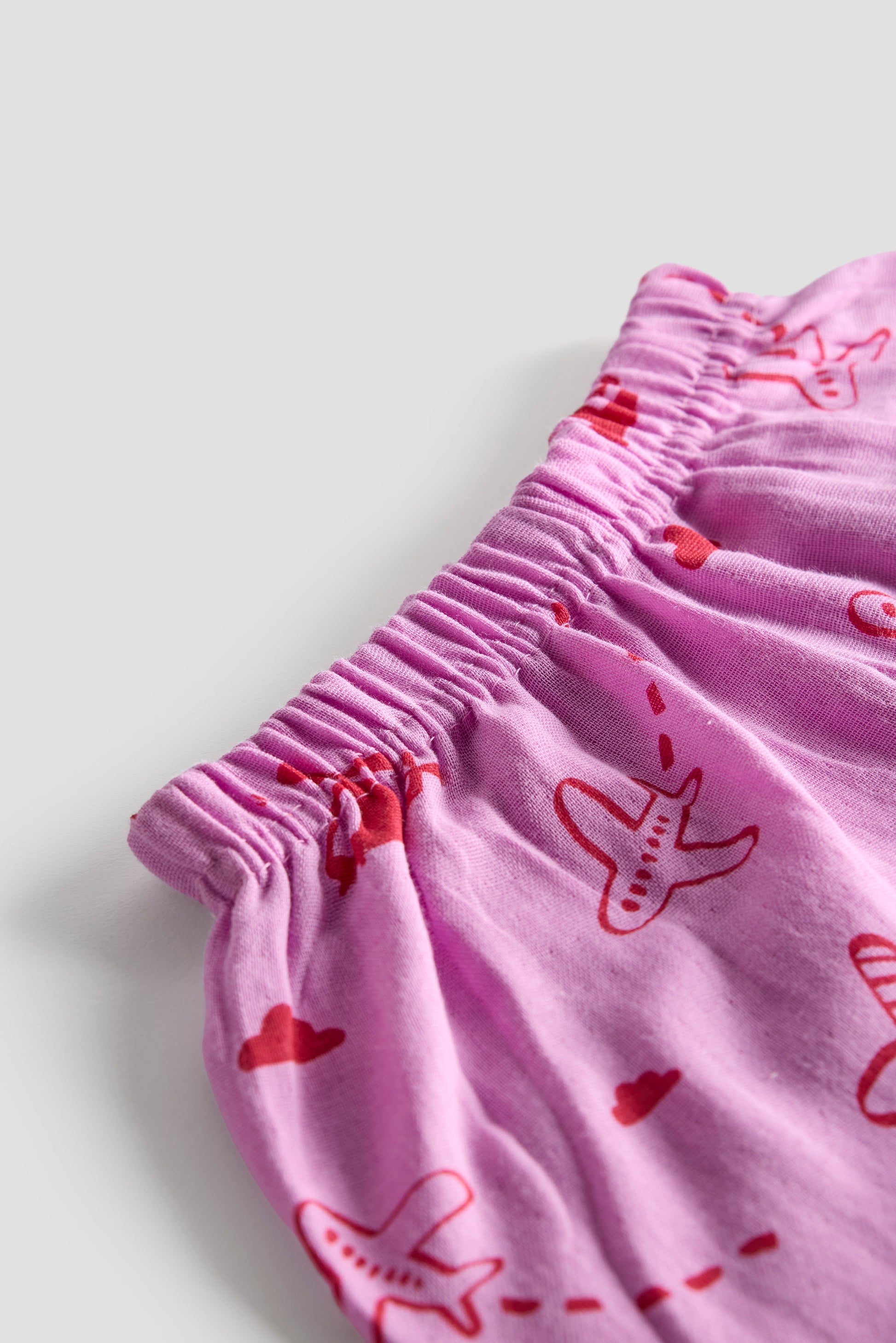 Pink fabric with red heart and fish patterns on a light gray background
