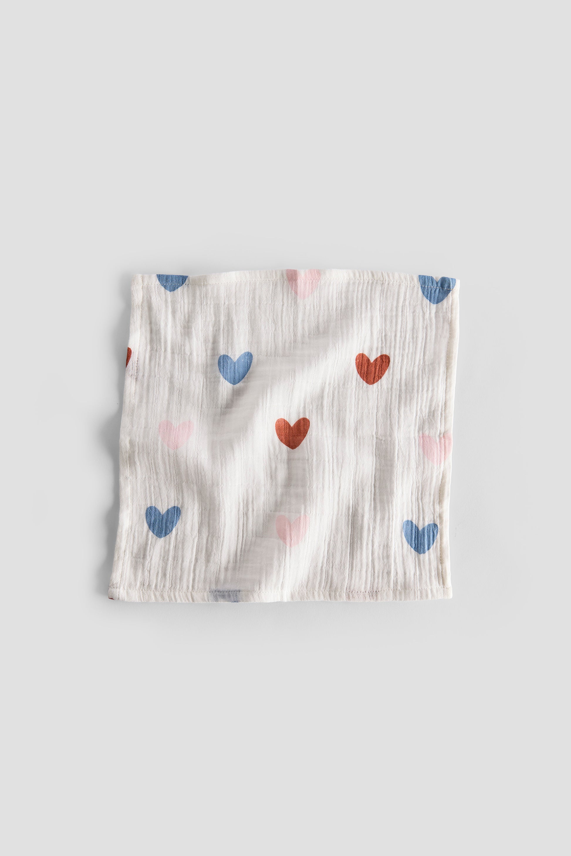 Baby blanket with heart patterns on a light gray background
