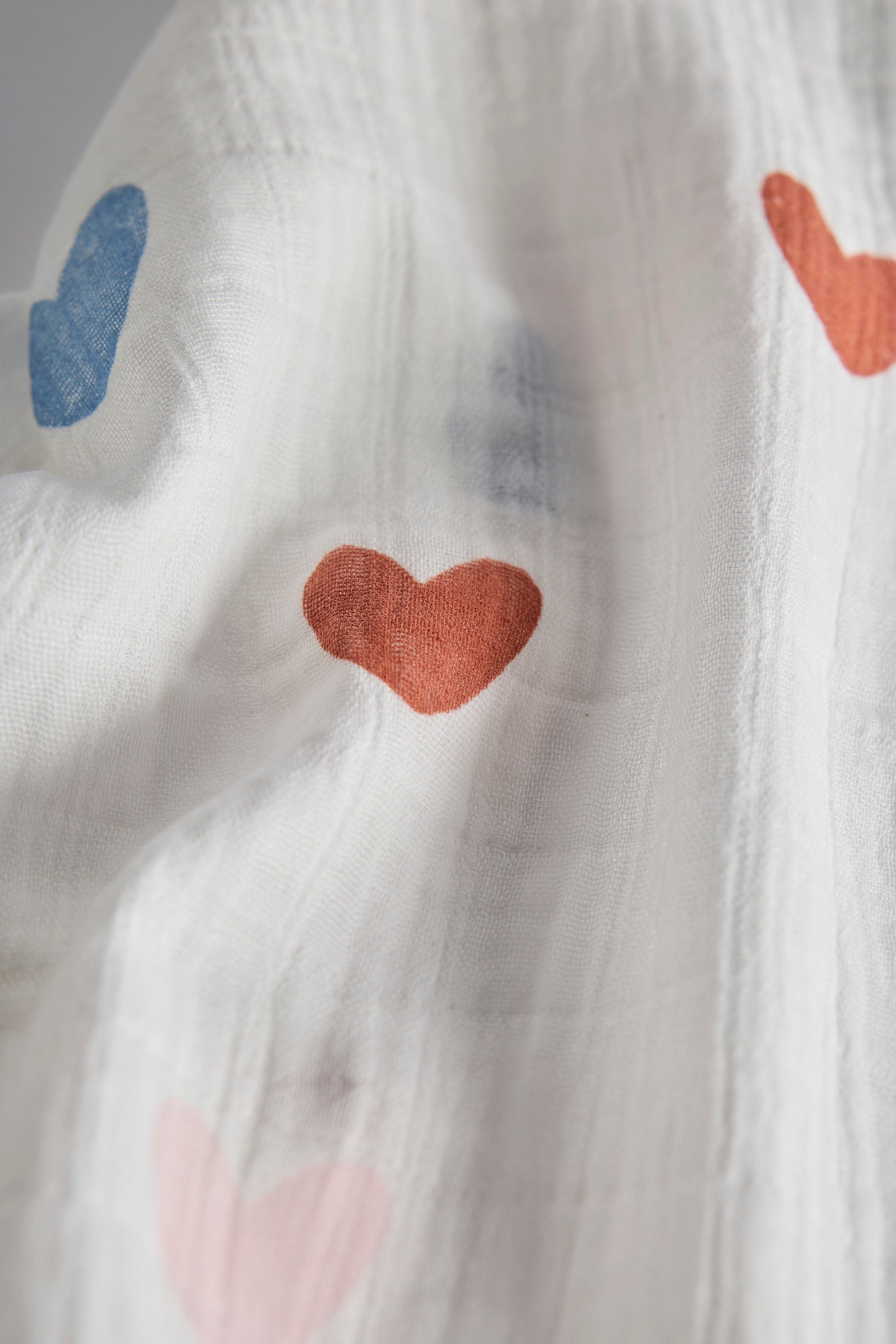 Close-up of a textured fabric with colorful heart shapes.