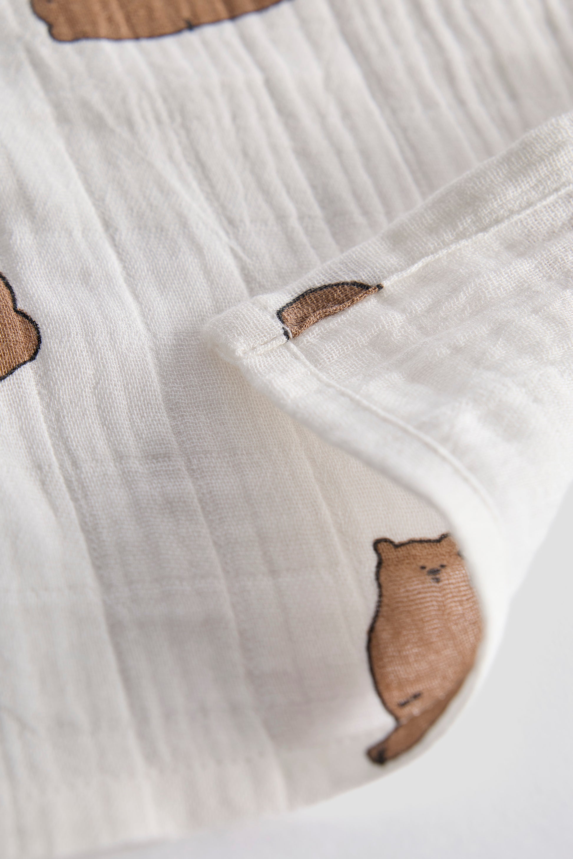 White fabric with brown bear illustrations