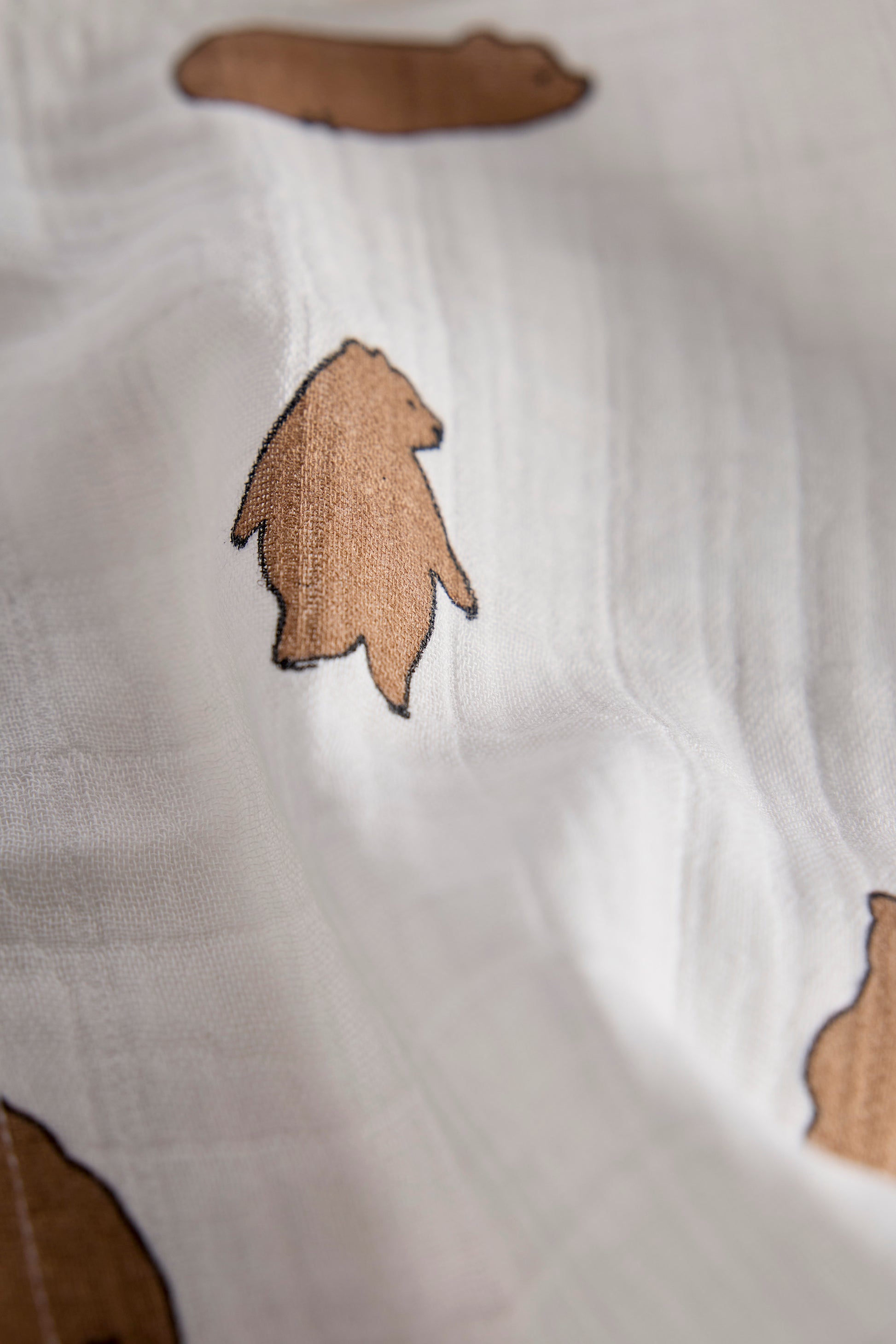 Brown arrowhead-like shapes on a white fabric background