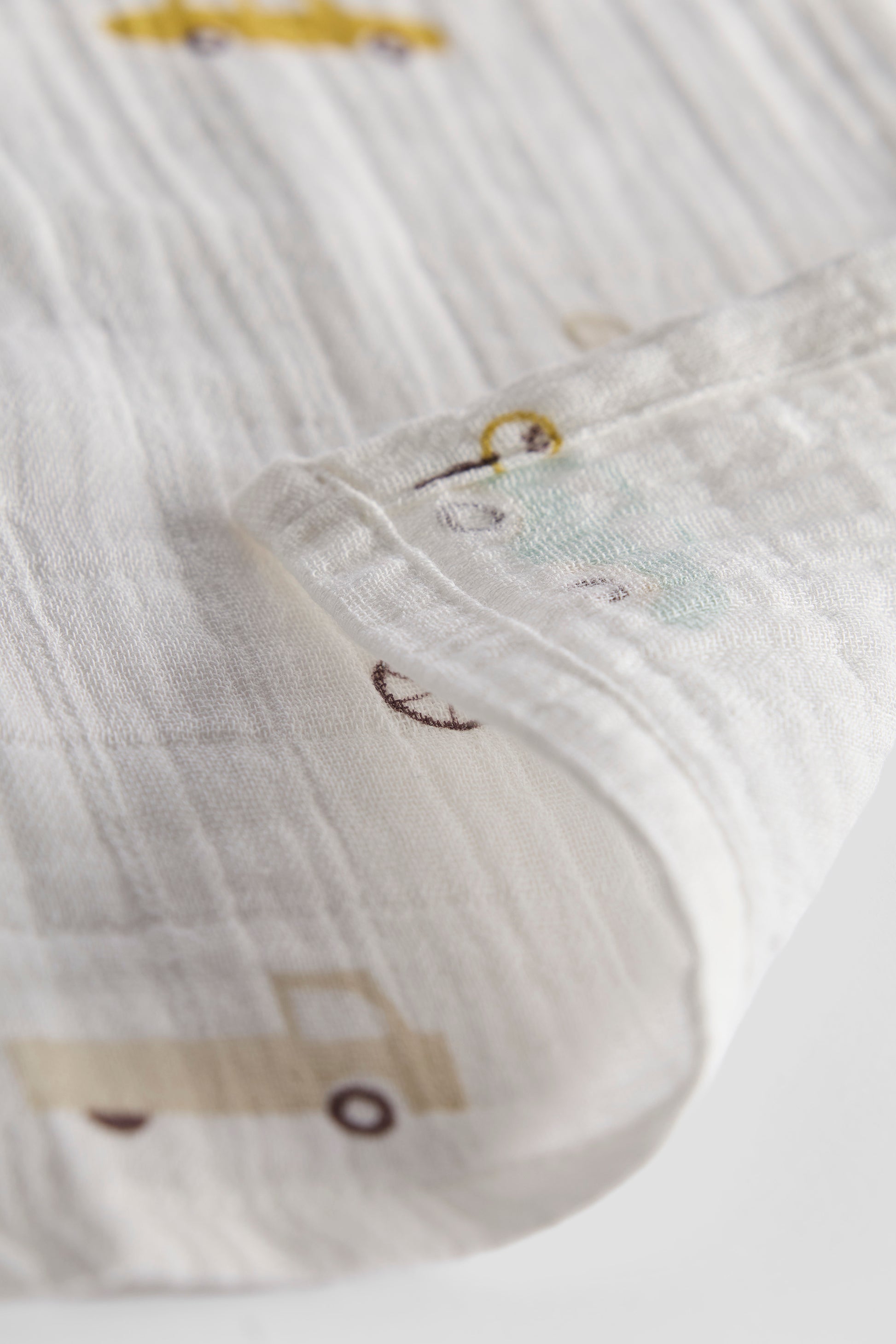 Close-up of a textured fabric with cartoon character designs on a white background