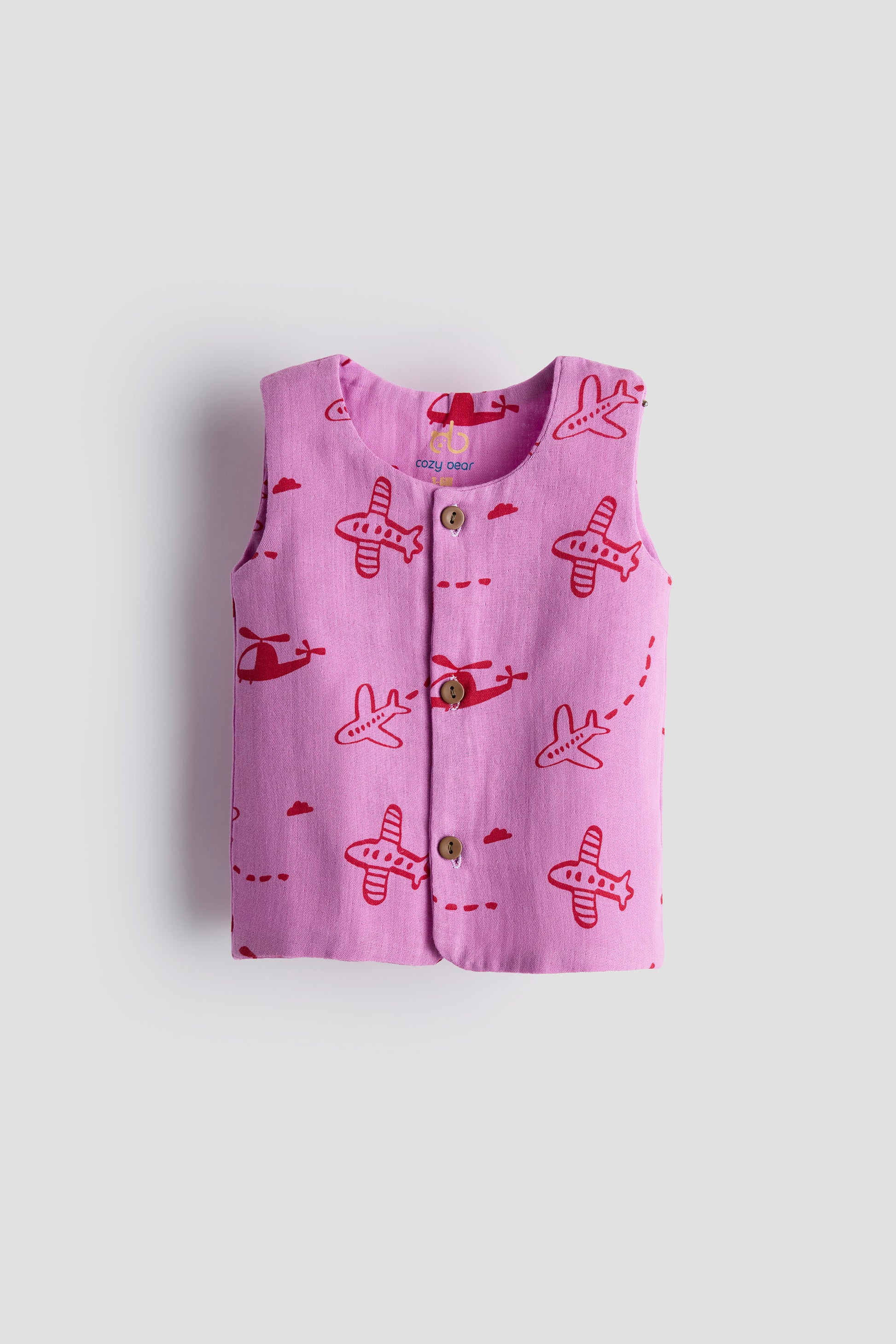 Pink children's vest with airplane pattern on a light gray background