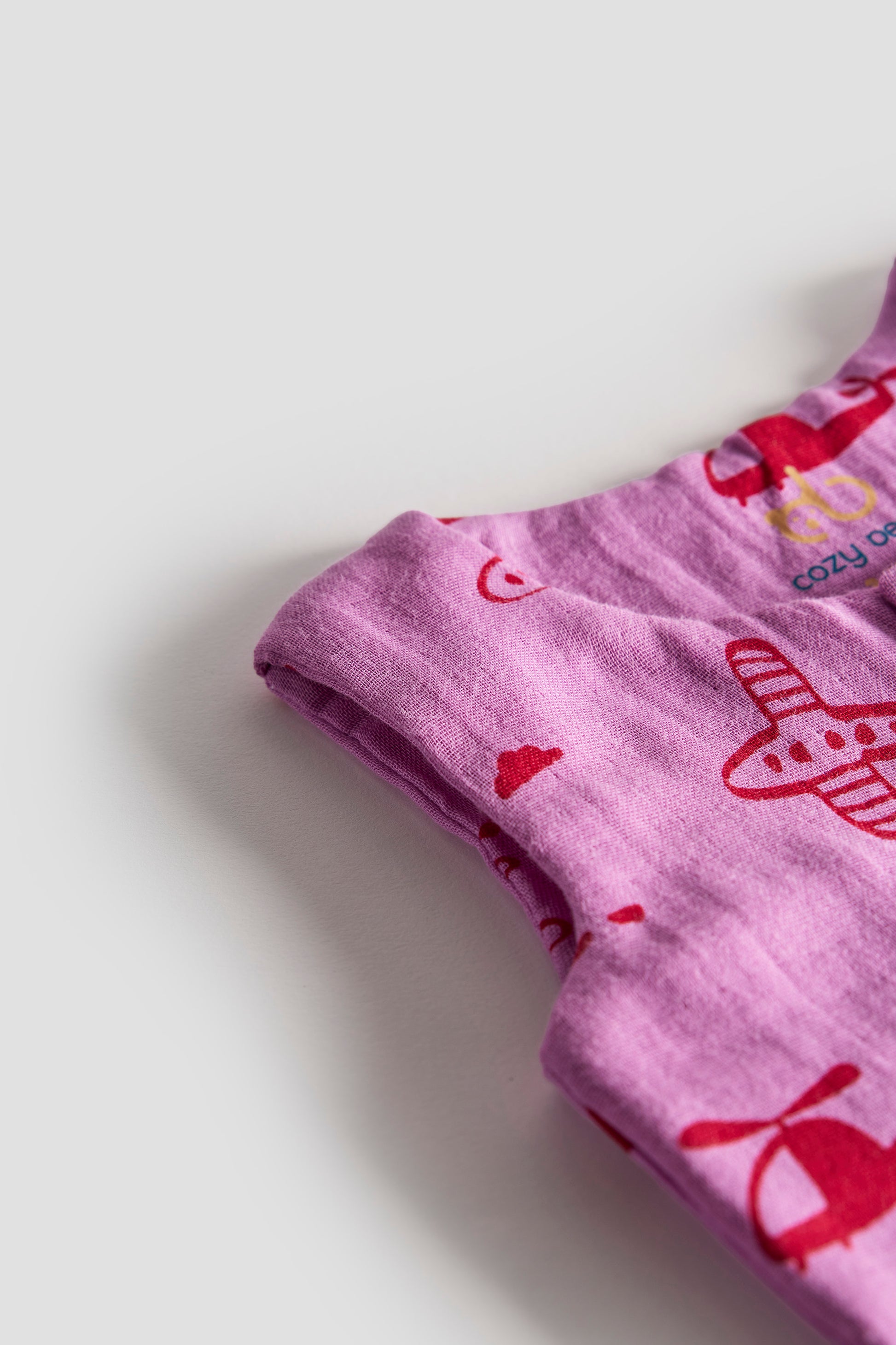 Purple fabric with red airplane patterns on a light gray background