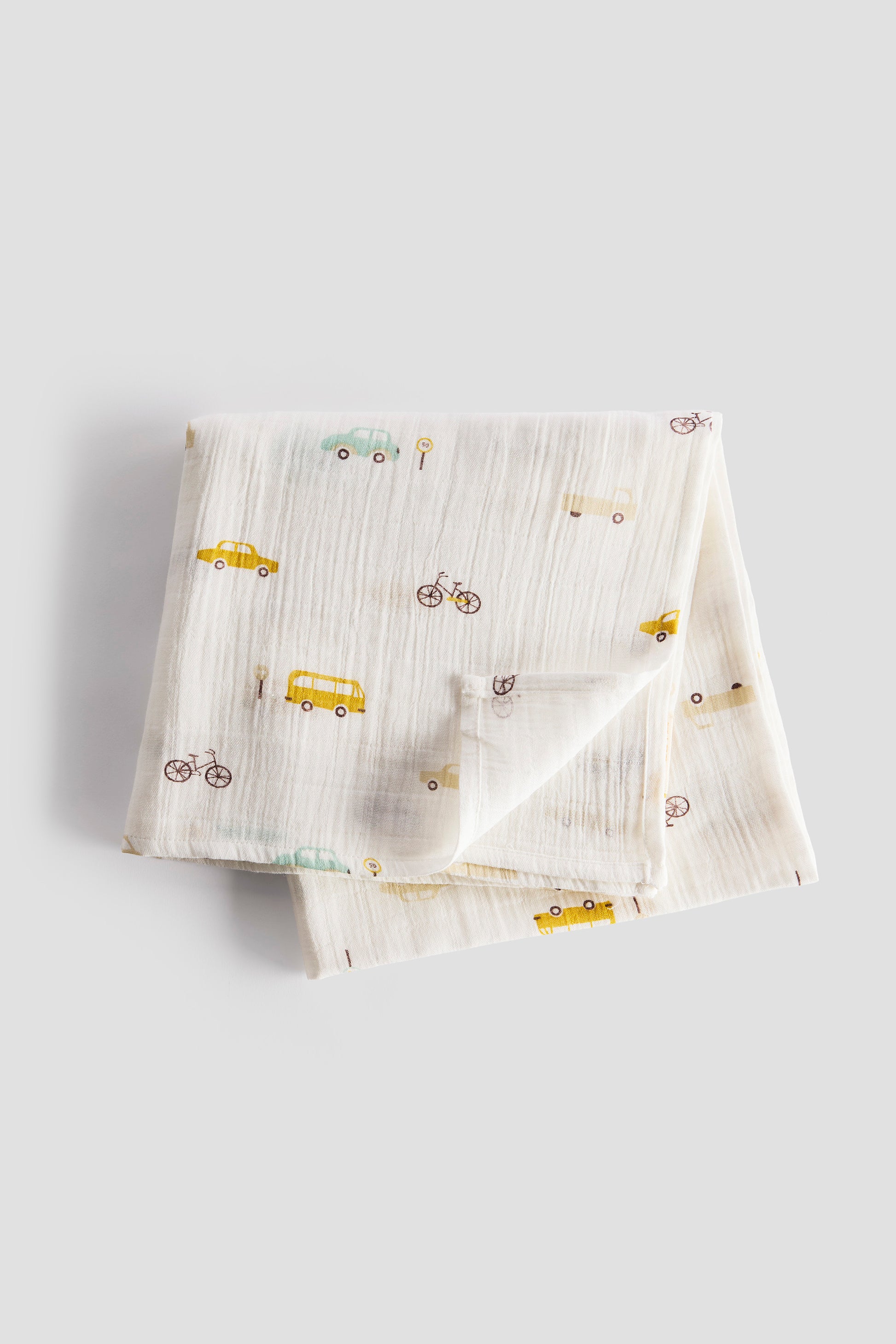 Folded fabric with vehicle patterns on a light gray background
