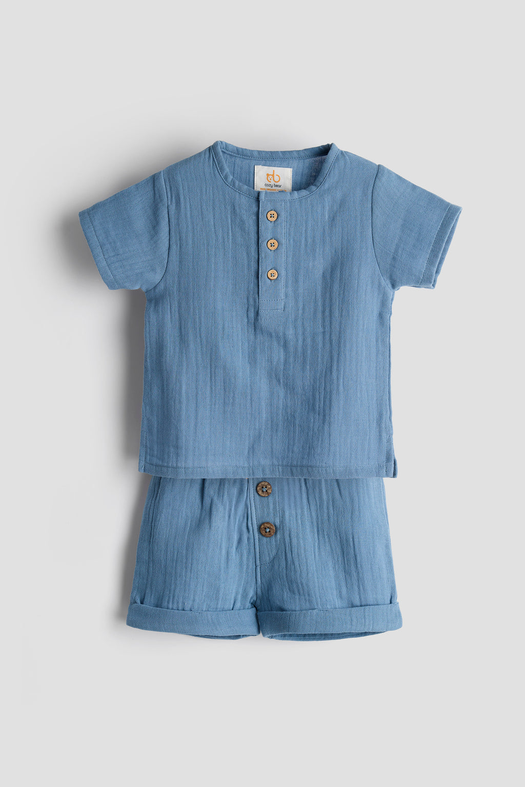 Blue baby romper with buttons on a light gray background