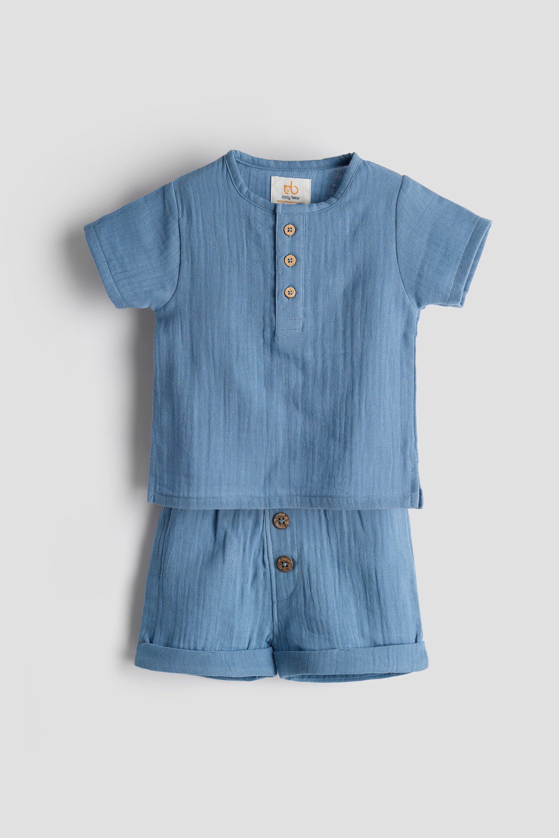 Blue baby romper with buttons on a light gray background
