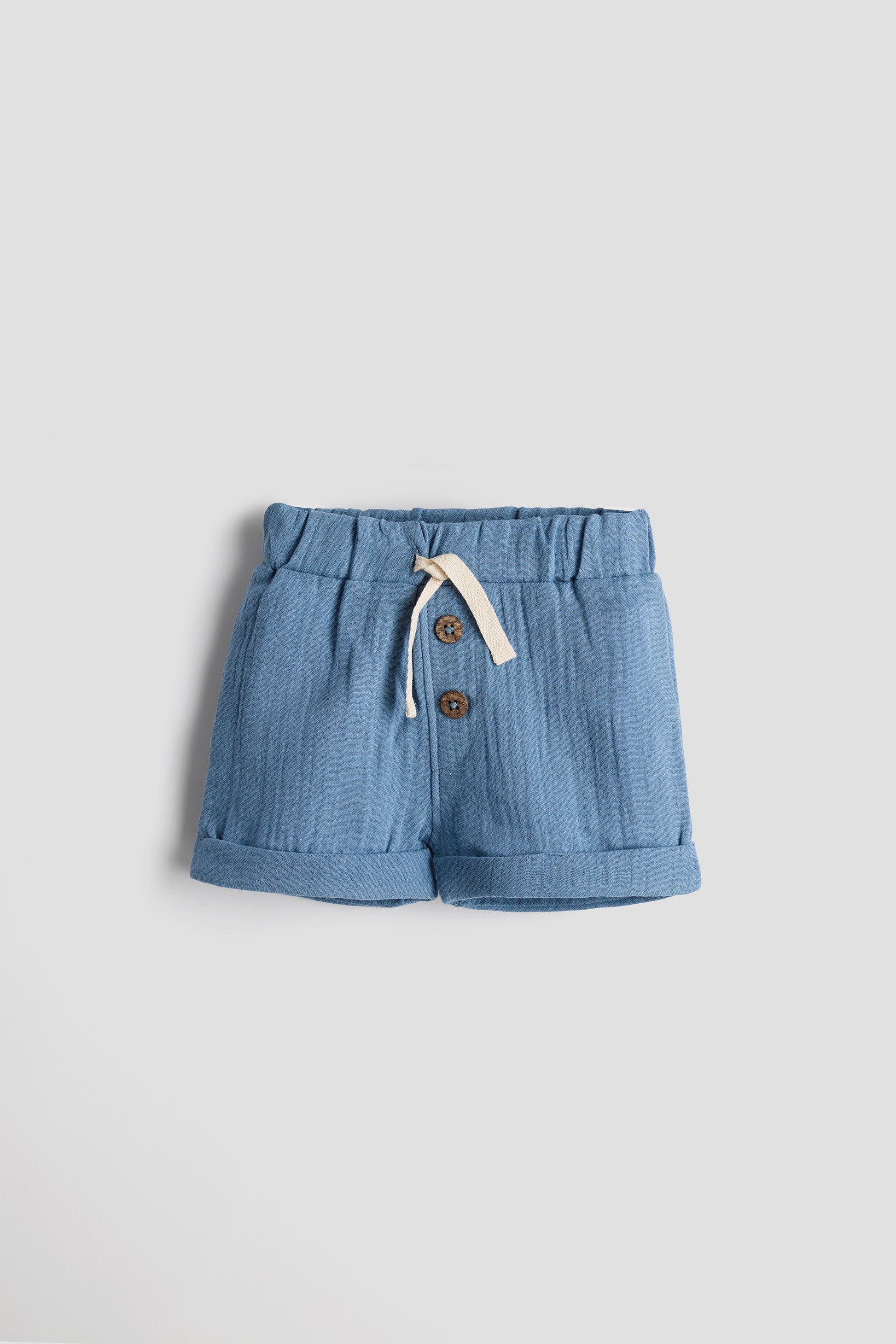 Blue shorts with buttons on a light gray background