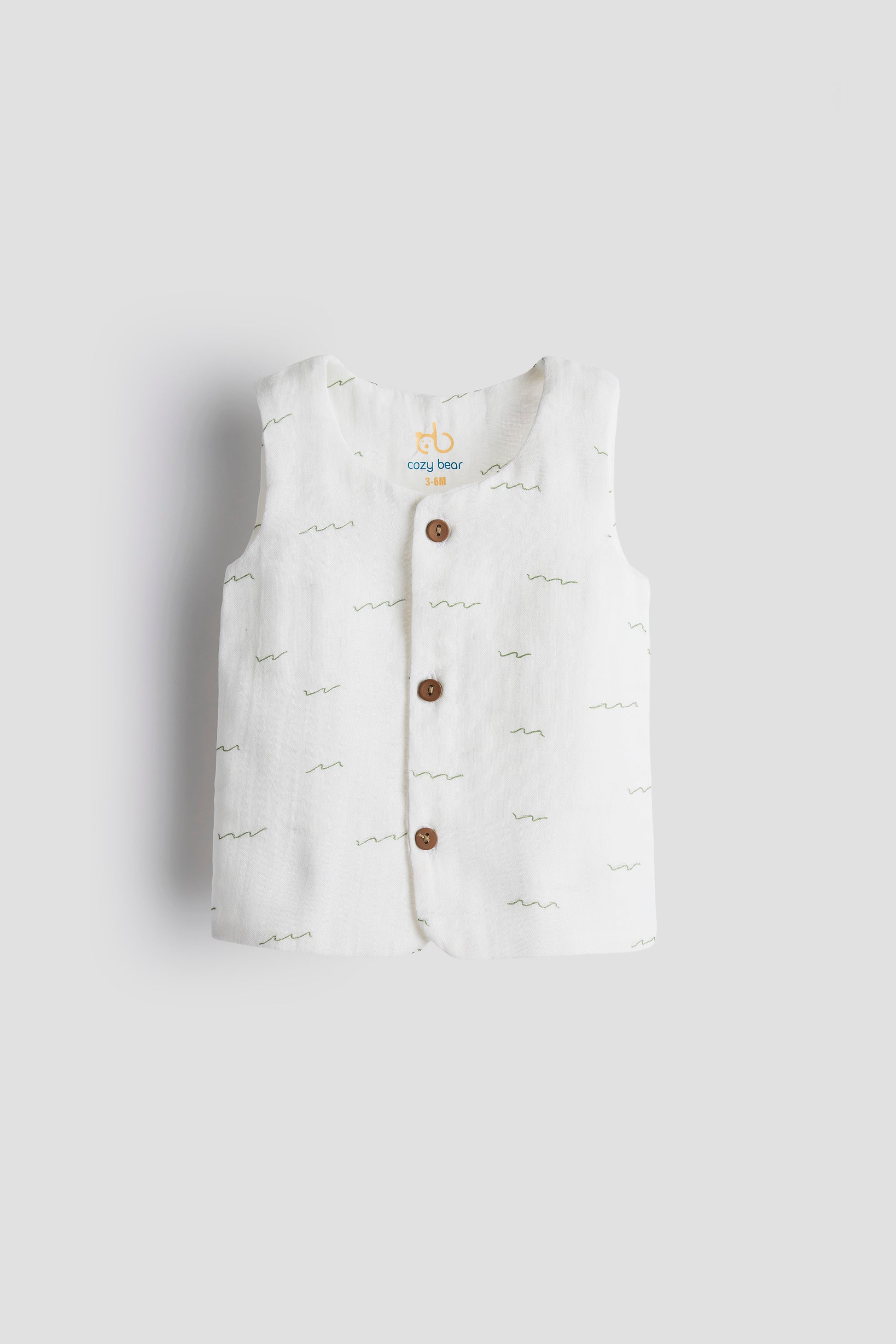 White baby romper with buttons on a light gray background