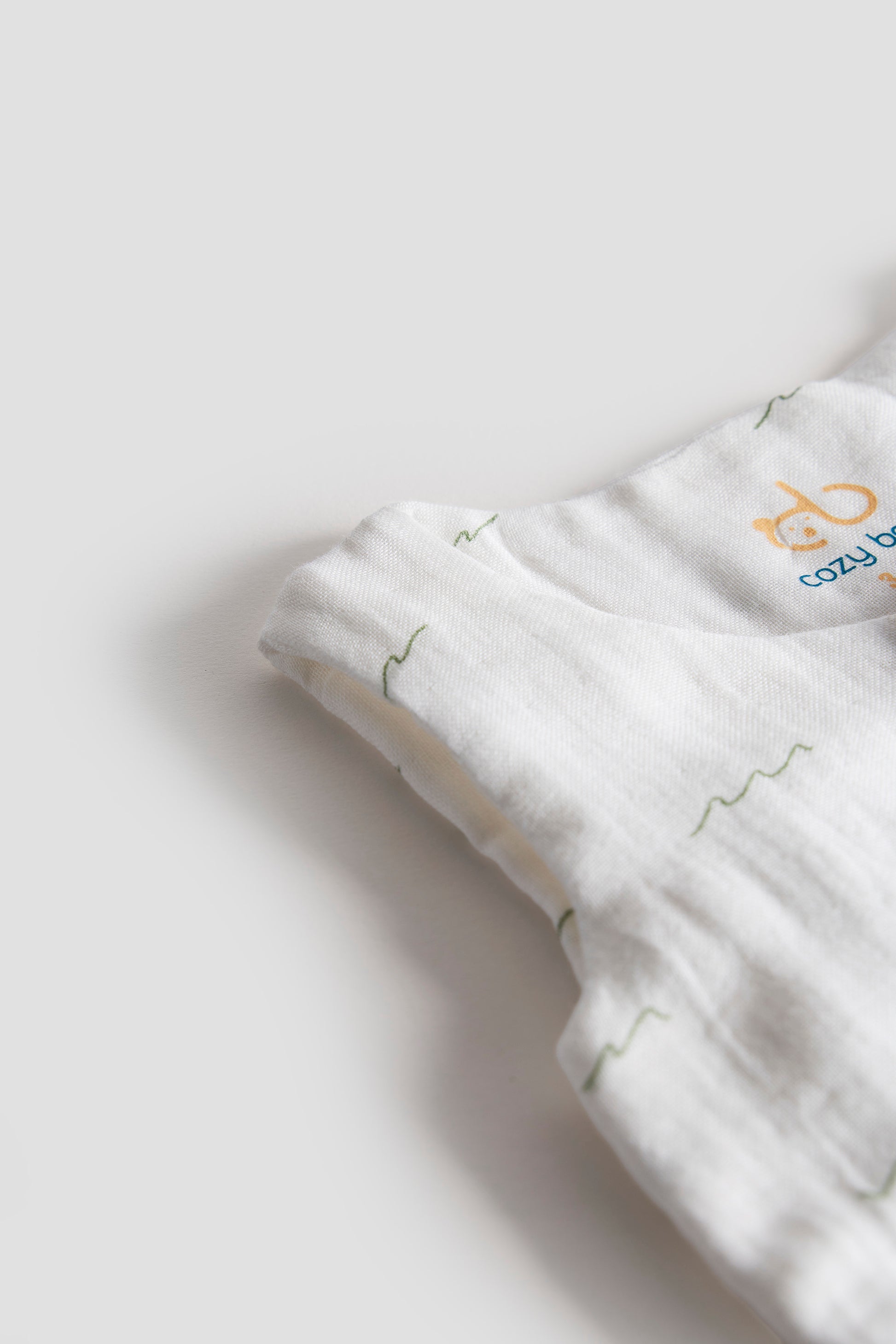 Folded white fabric with a subtle pattern on a light gray background