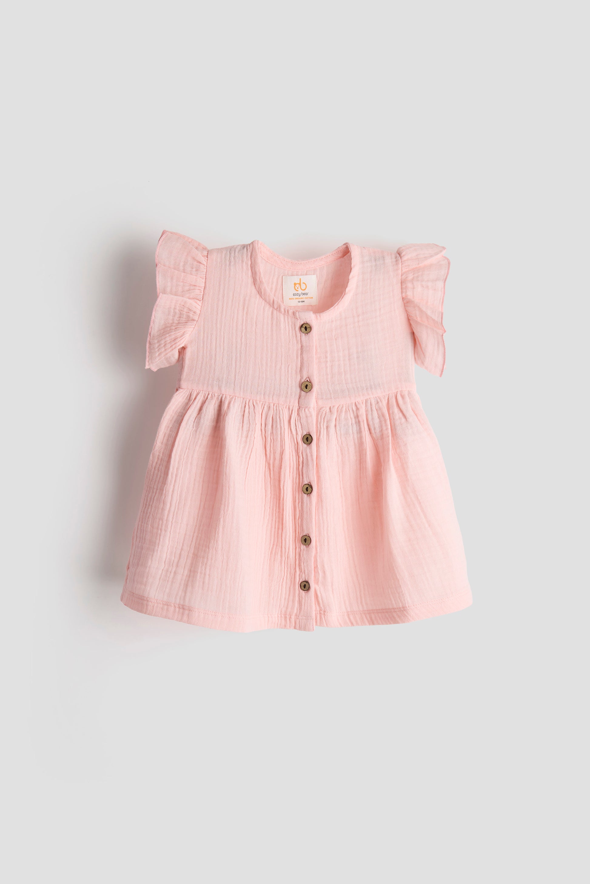Pink dress with buttons on a light gray background