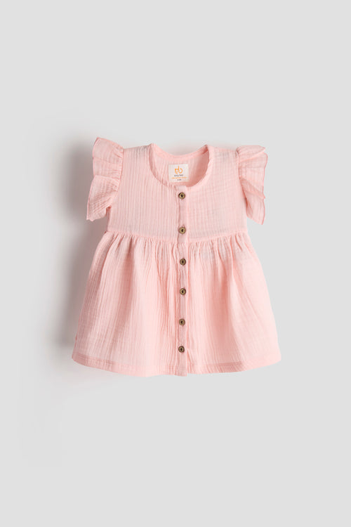 Pink dress with buttons on a light gray background