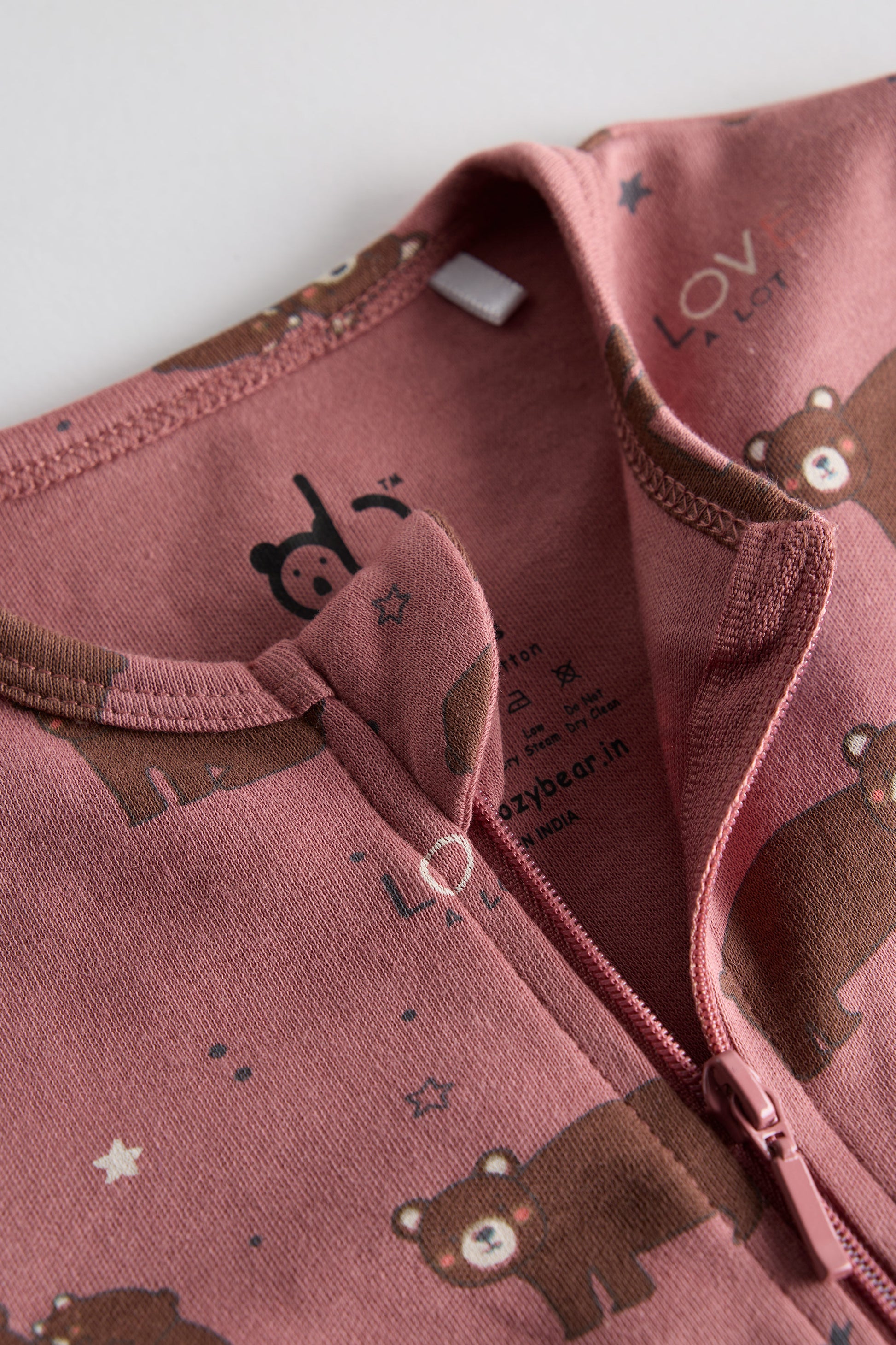 Berry-colored organic cotton baby sleep suit with cute bear print and zipper, by Cozy Bear.