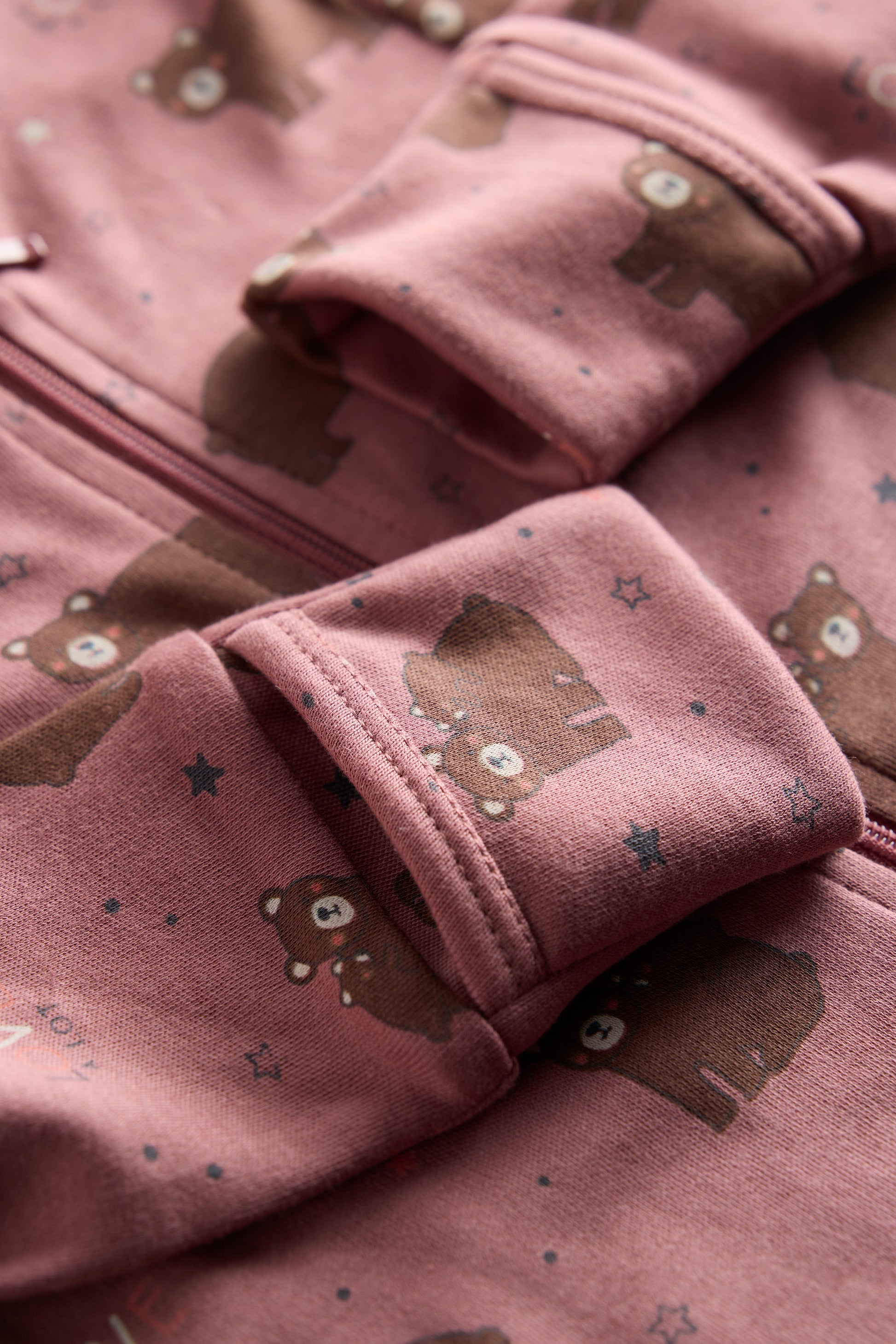 Berry-colored organic cotton baby sleep suit with cute bear print and zipper, by Cozy Bear.