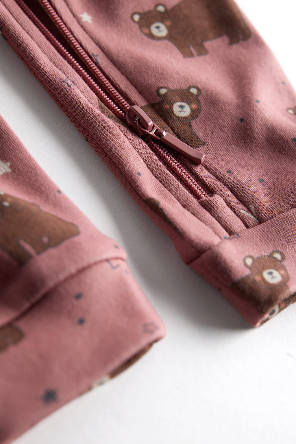 Berry-colored organic cotton baby sleep suit with cute bear print and zipper, by Cozy Bear.