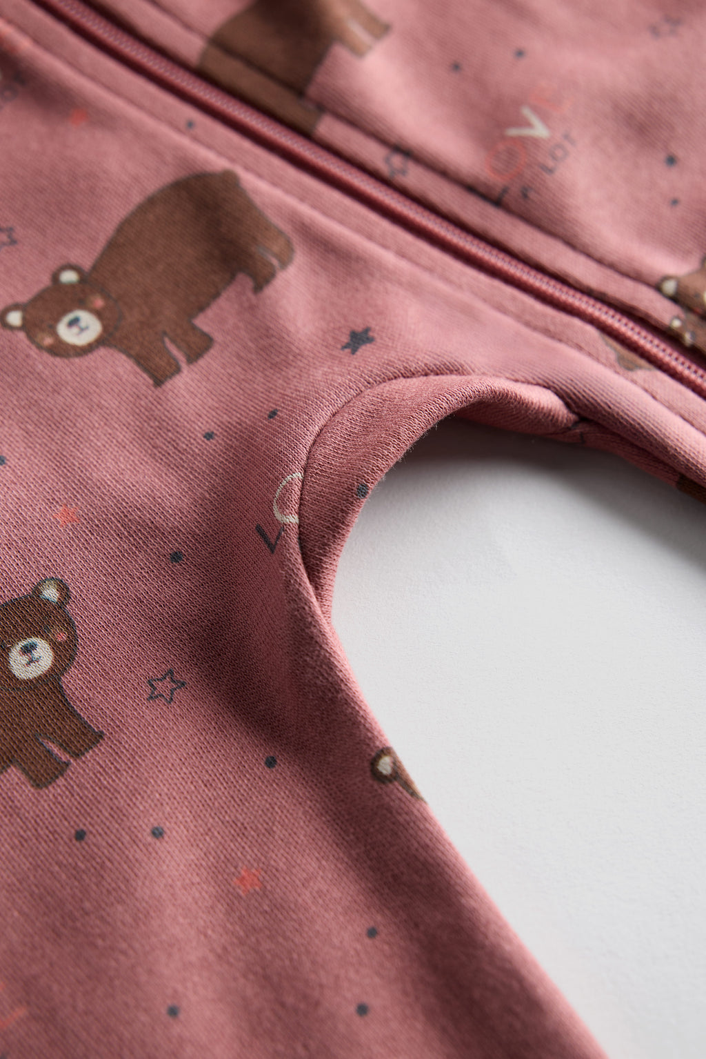 Berry-colored organic cotton baby sleep suit with cute bear print and zipper, by Cozy Bear.