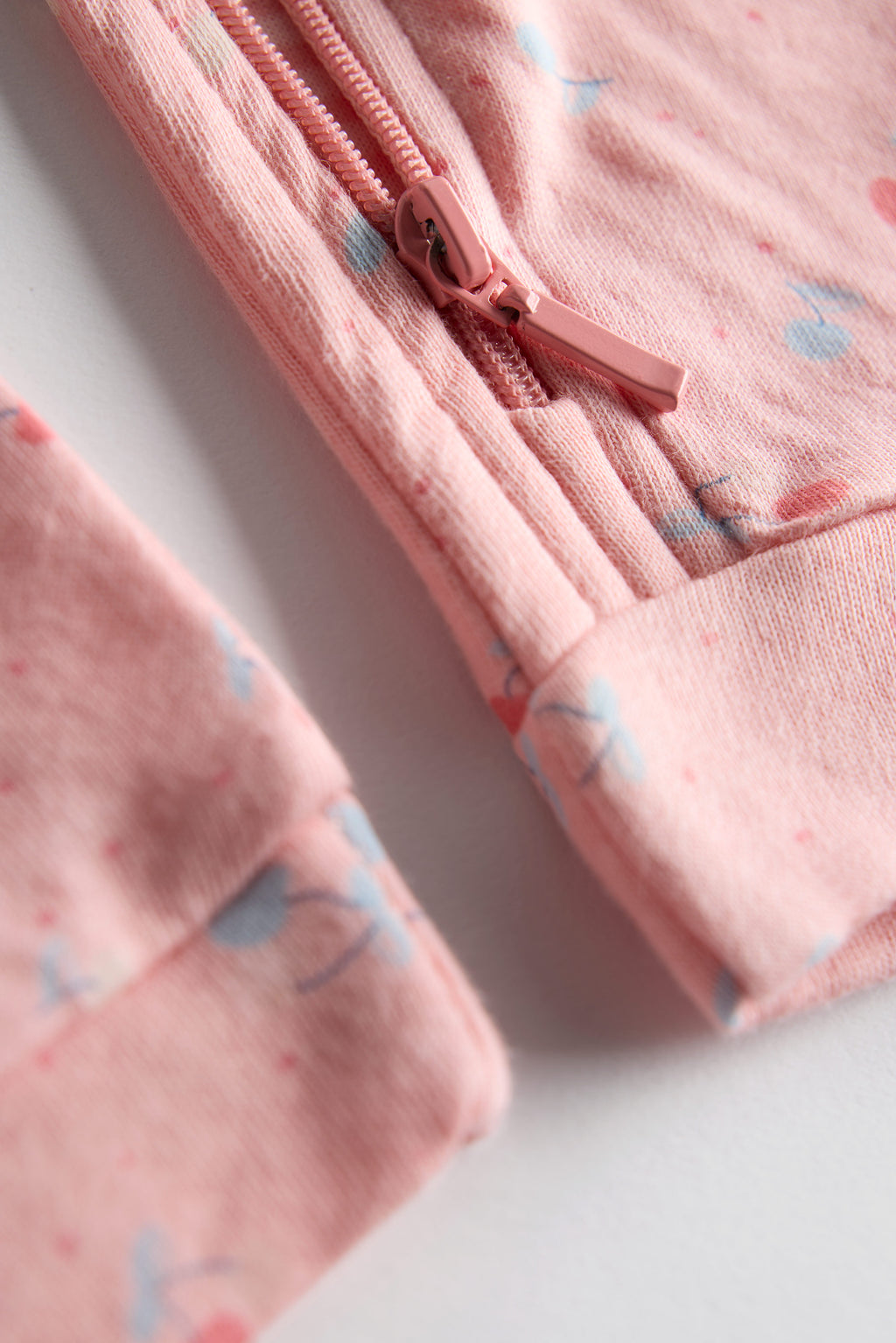Close-up of a pink children's jacket with a zipper on a light background