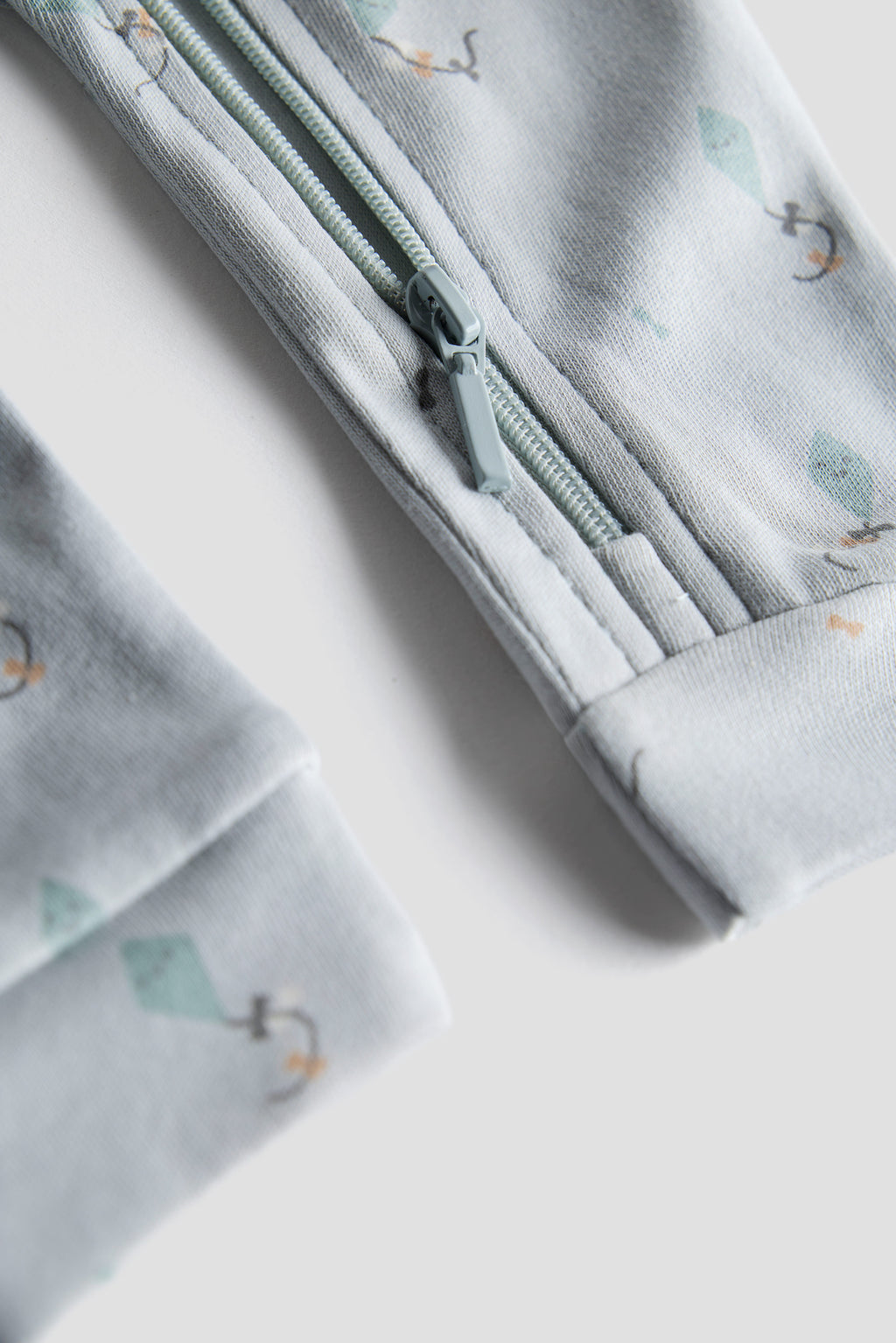 Folded fabric with a zipper and small tree pattern on a light background