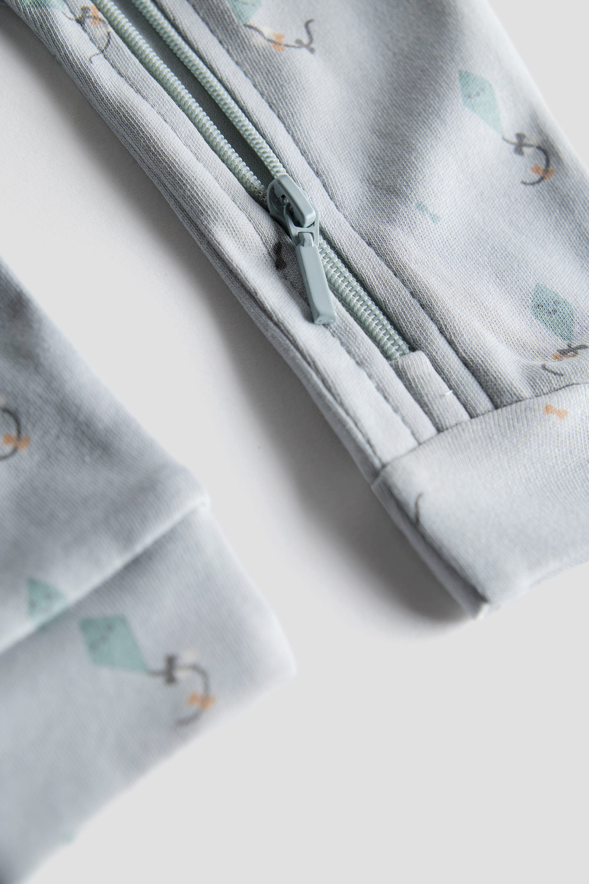 Folded fabric with a zipper and small tree pattern on a light background