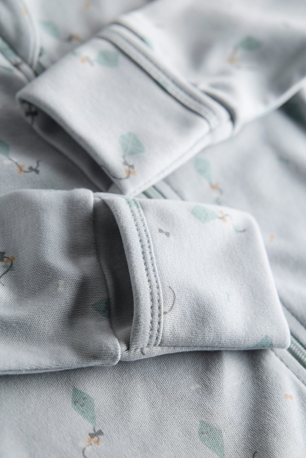 Close-up of light gray fabric with subtle patterns, possibly pajama pants.