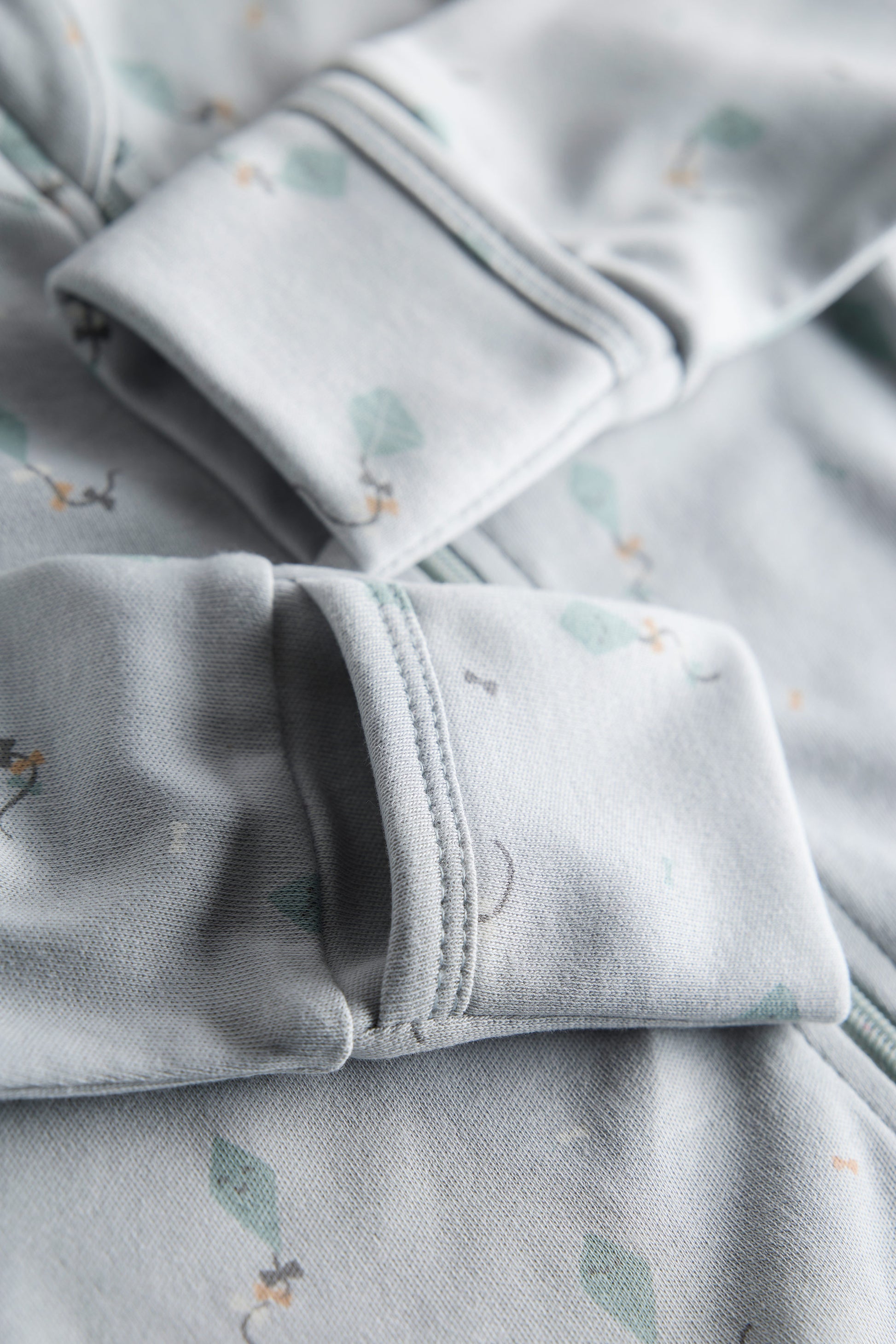 Close-up of light gray fabric with subtle patterns, possibly pajama pants.