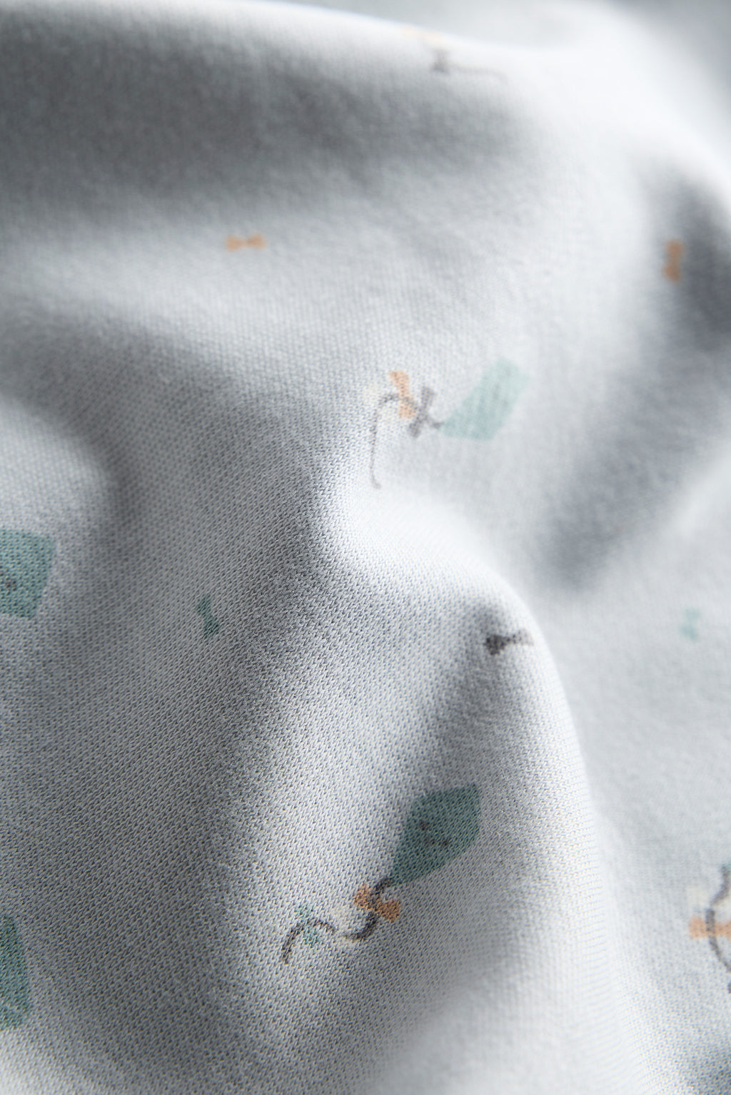 Close-up of gray fabric with small green leaf patterns