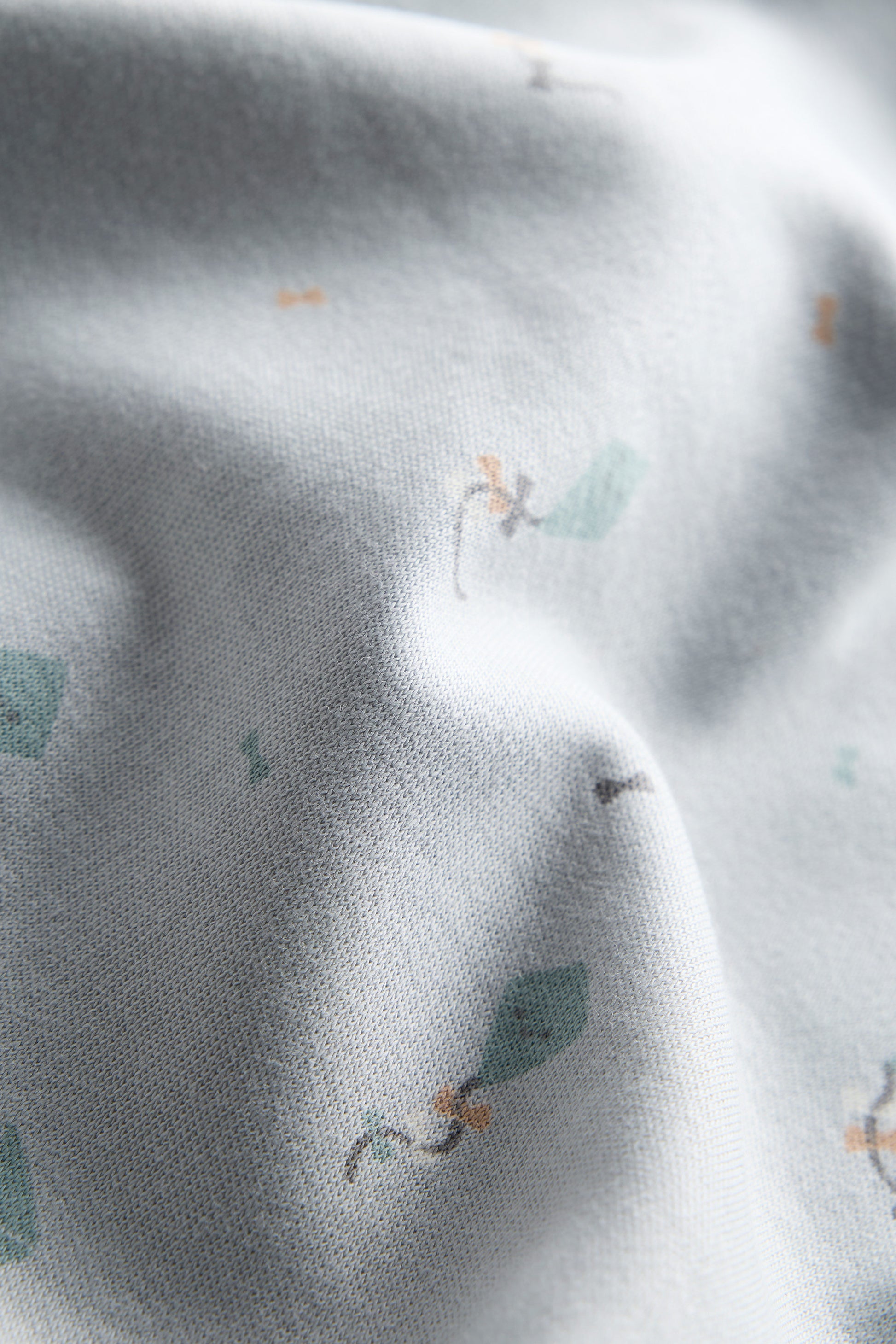 Close-up of gray fabric with small green leaf patterns