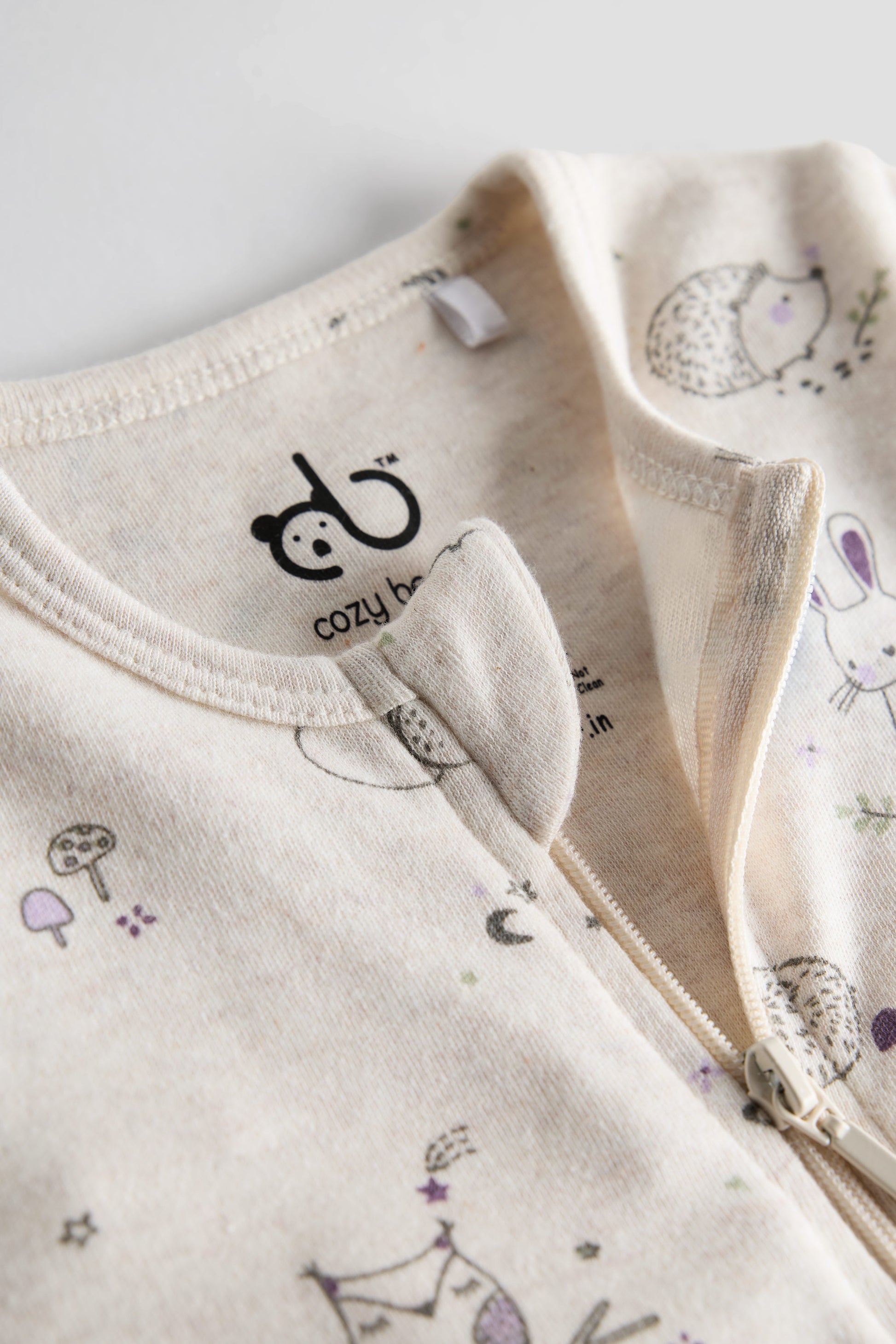 Cream organic cotton baby sleep suit with forest animal print and zipper, certified safe by Cozy Bear.