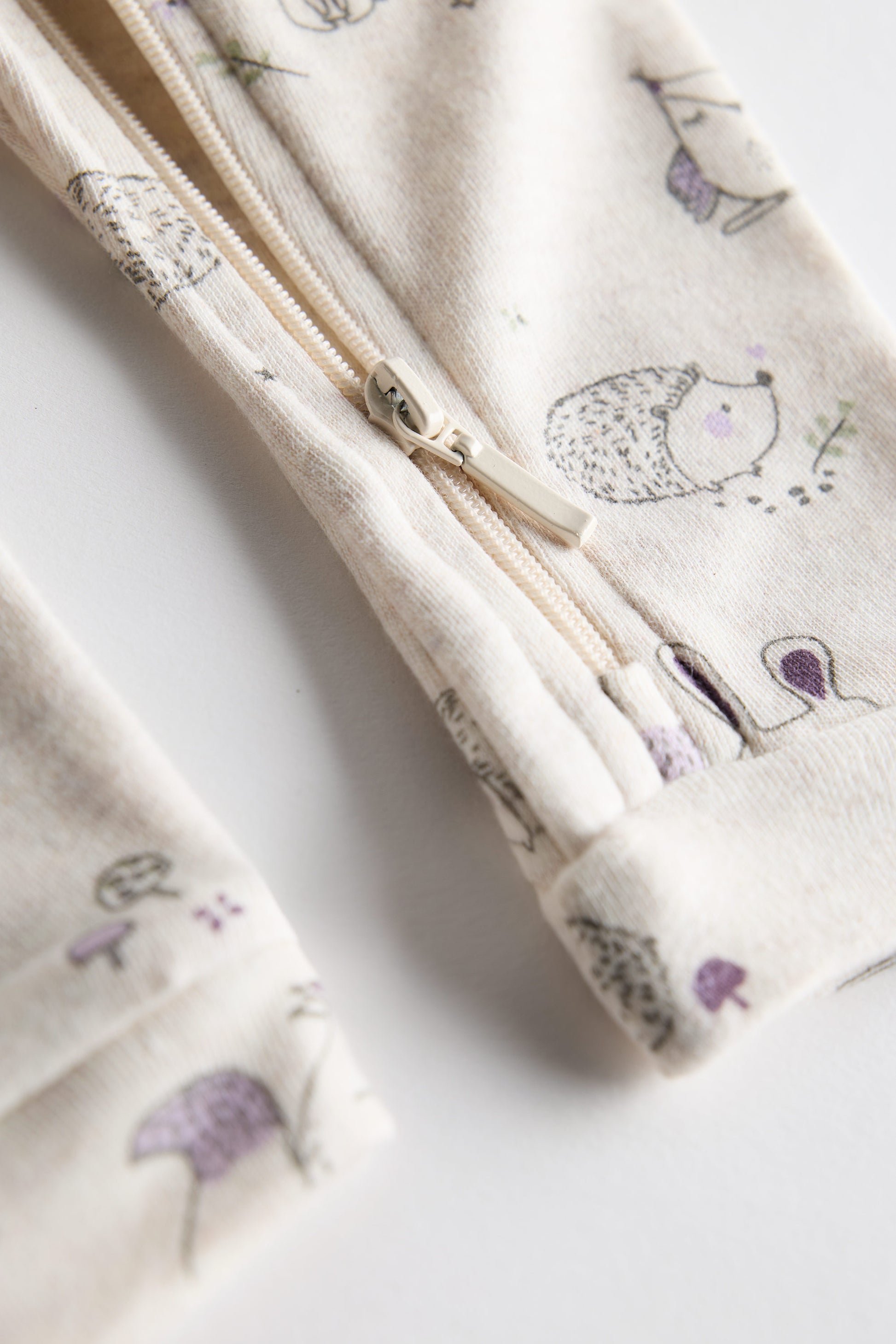 Cream organic cotton baby sleep suit with forest animal print and zipper, certified safe by Cozy Bear.