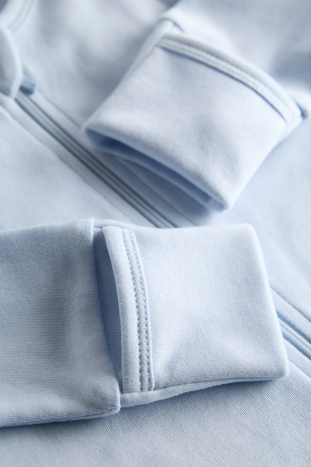 Close-up of light blue fabric with a focus on texture and stitching.