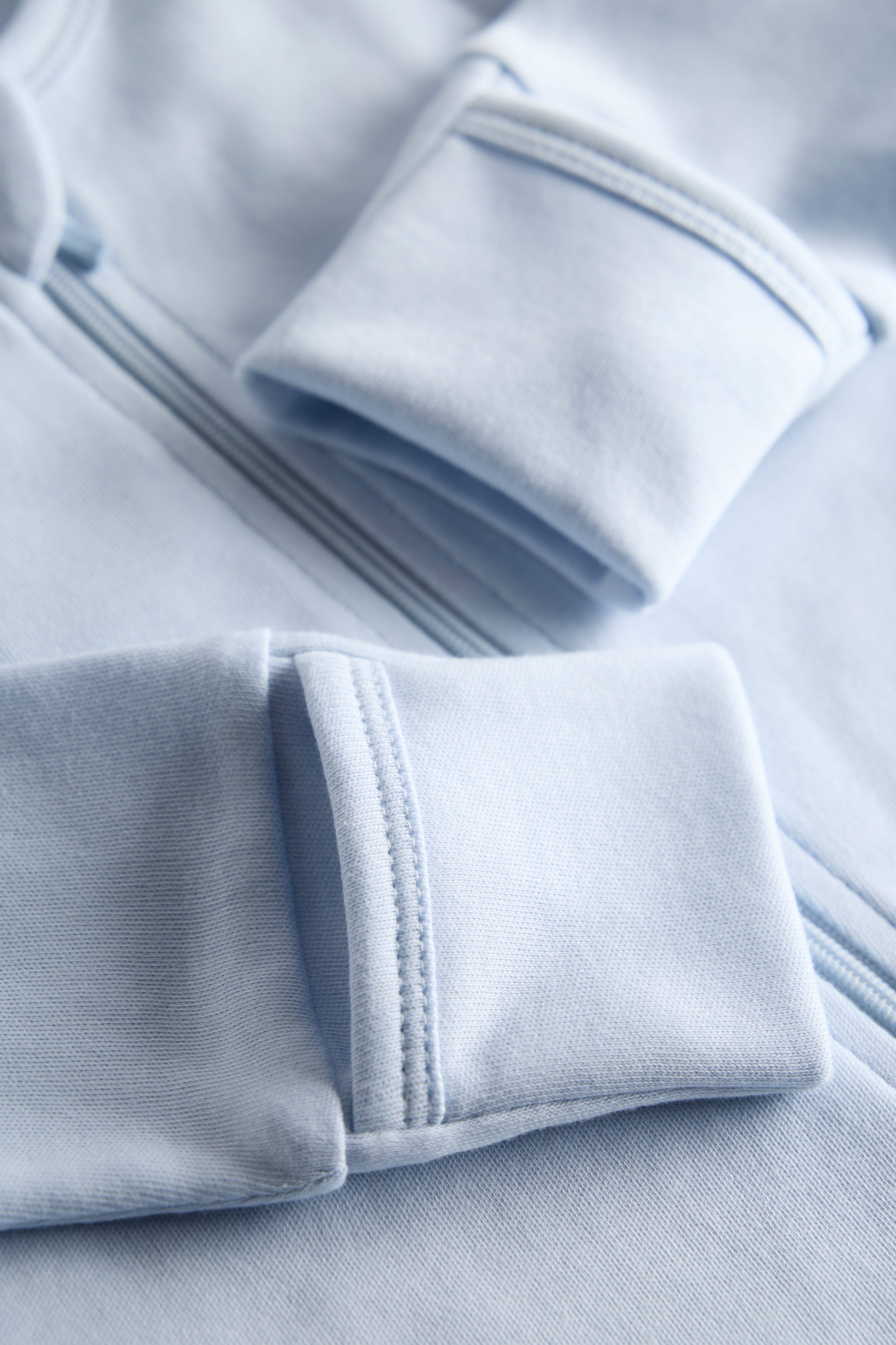 Close-up of light blue fabric with a focus on texture and stitching.