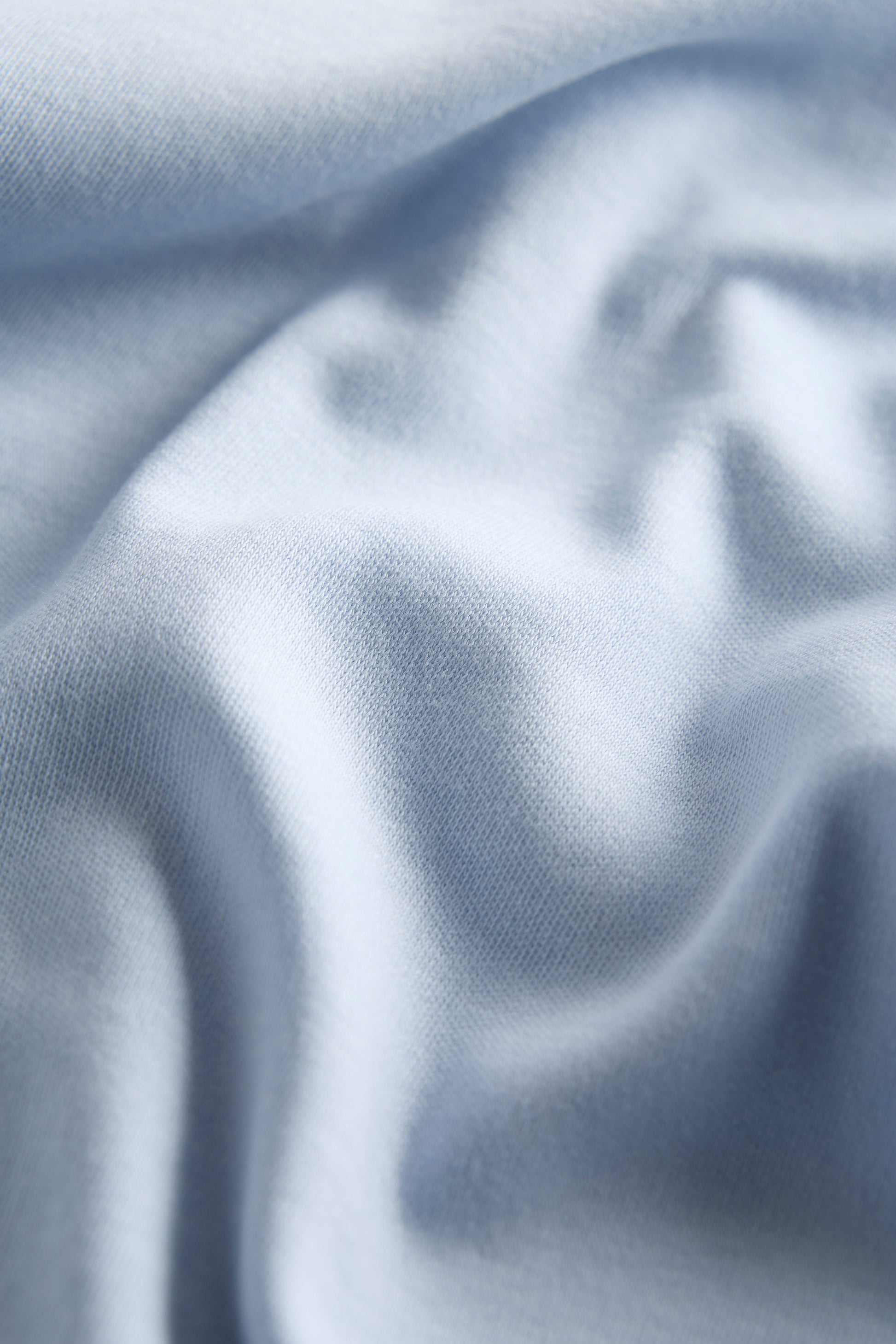 Close-up of textured light blue fabric with folds
