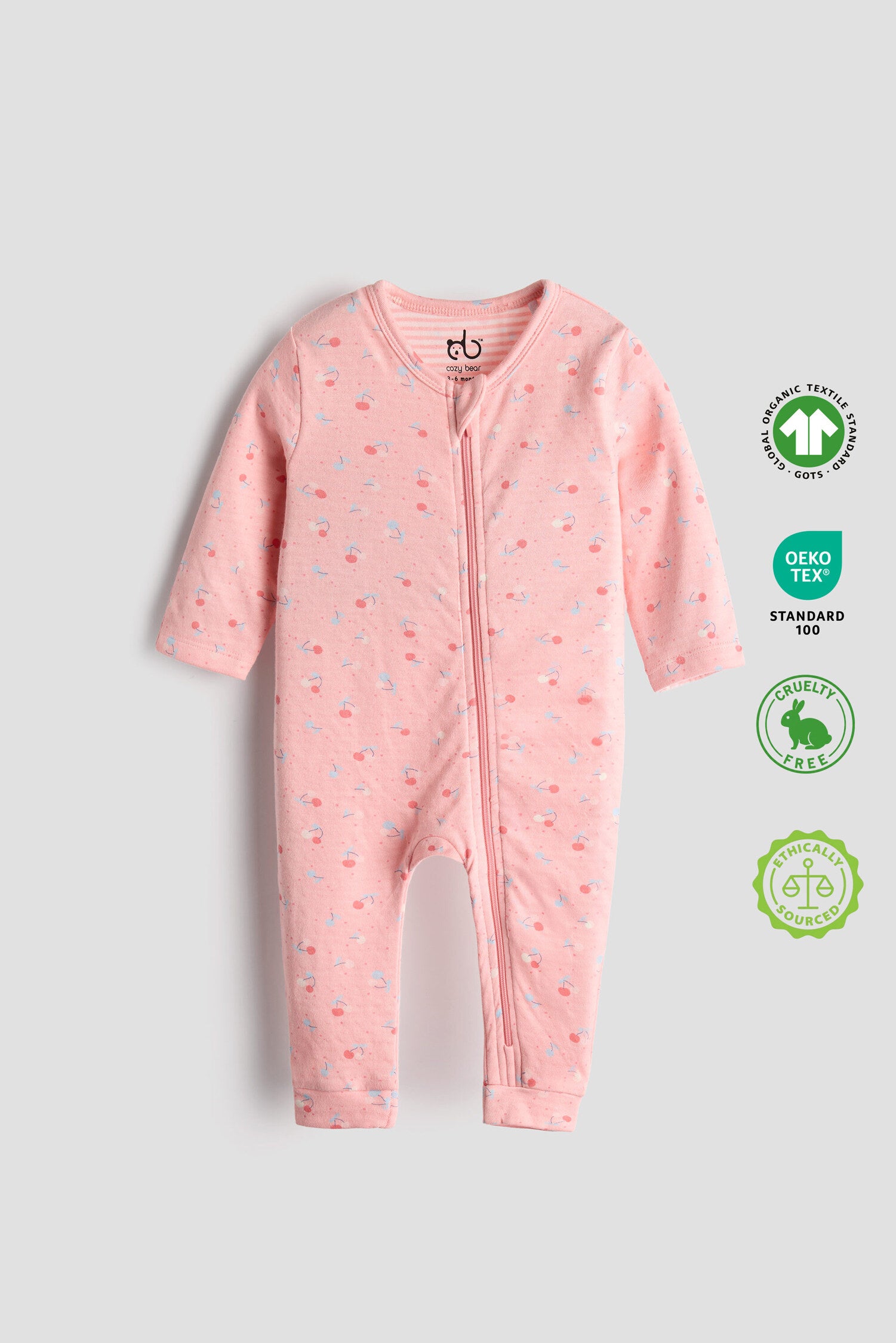 Pink organic cotton baby sleep suit with cherry print and zipper, certified safe and ultra-soft by Cozy Bear.