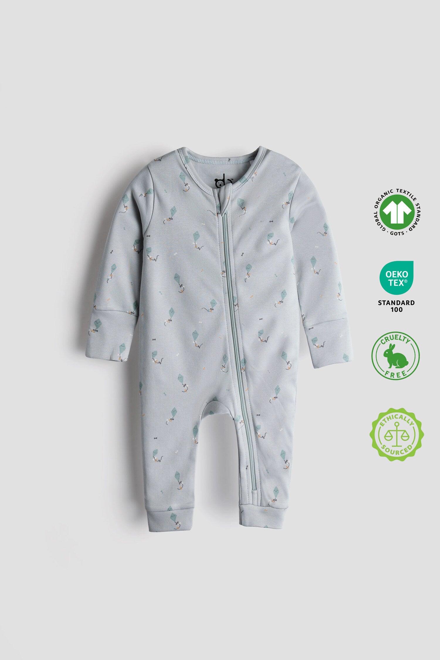 Gray baby onesie with printed designs on a light gray background Light blue organic cotton baby sleep suit with kite print and zipper, GOTS certified and crafted by Cozy Bear.