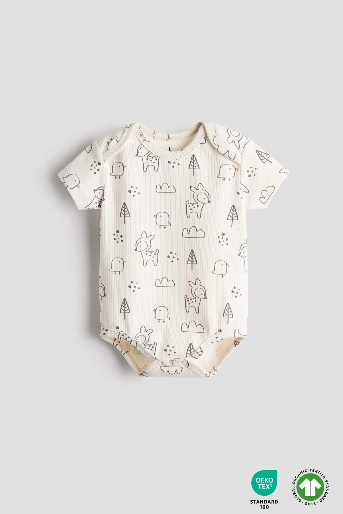 Baby onesie with animal pattern on a light gray background