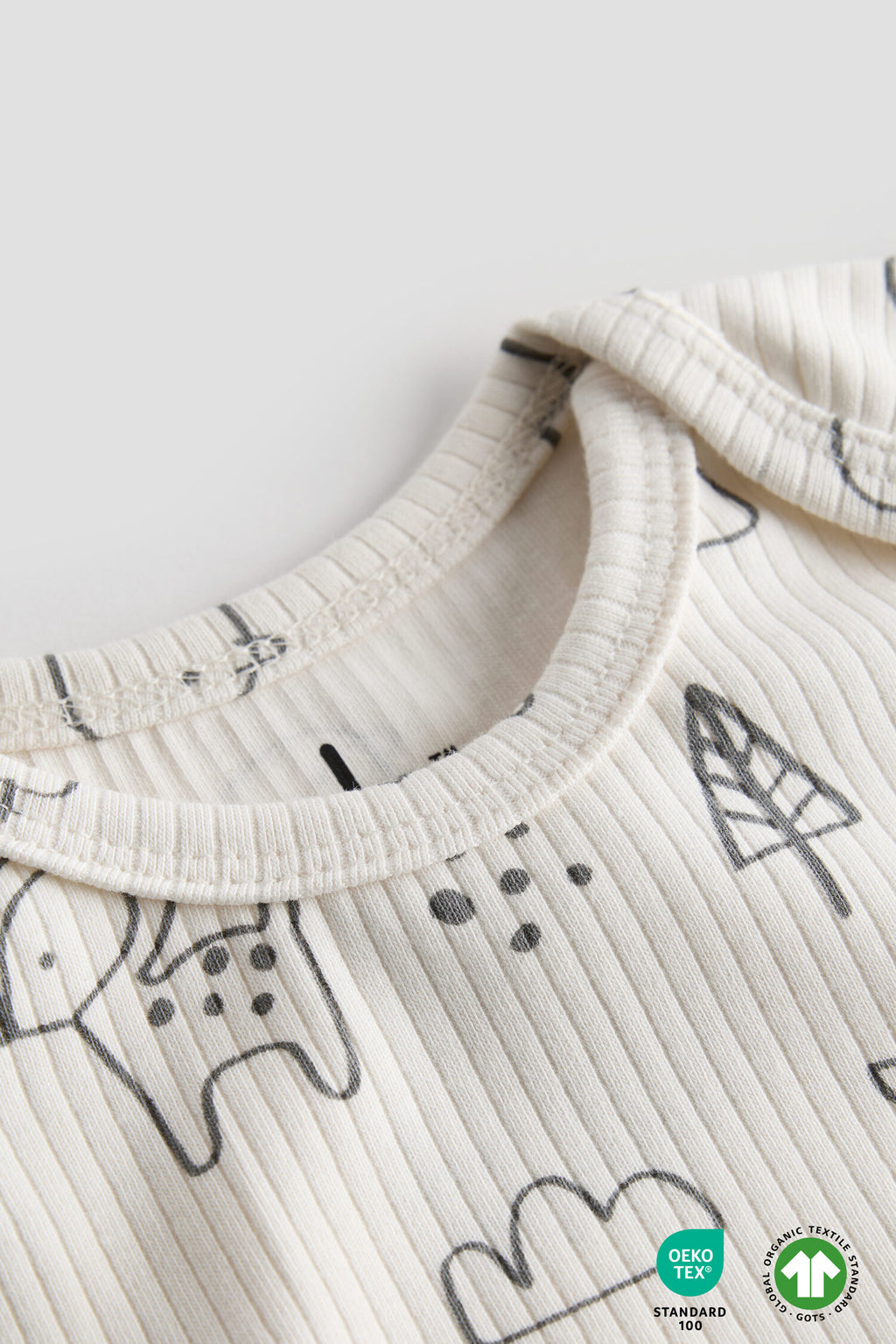 Close-up of a baby outfit with black patterns on a white background