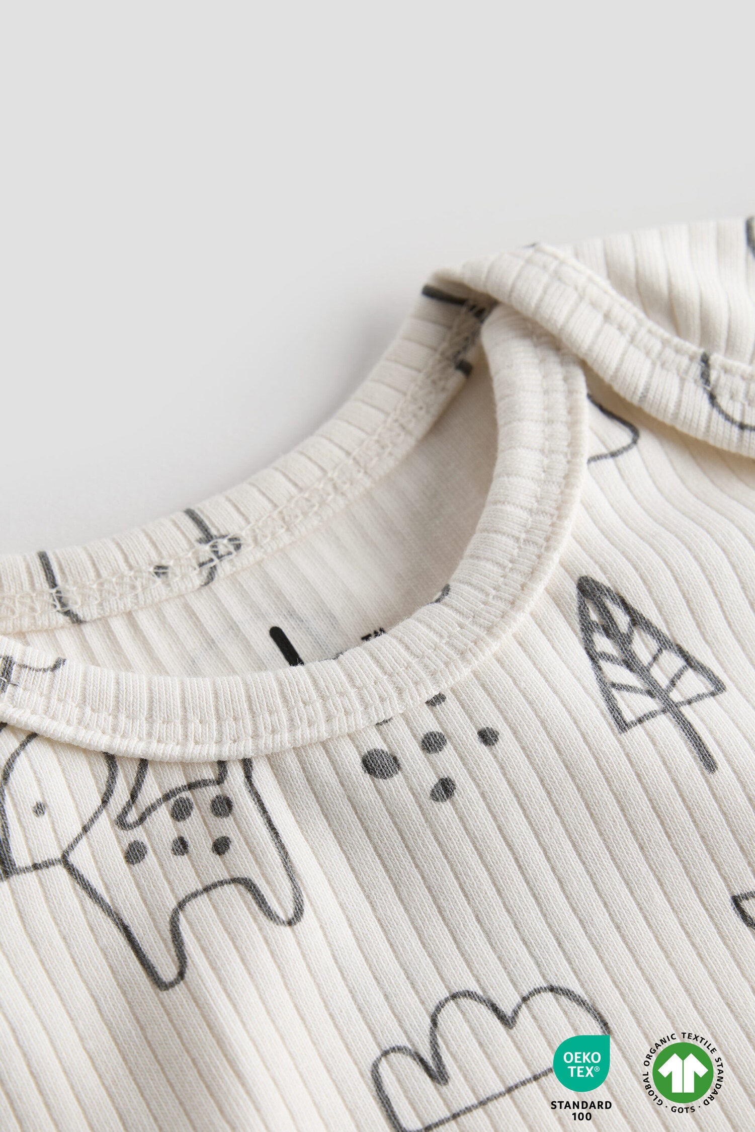 Close-up of a baby outfit with black patterns on a white background